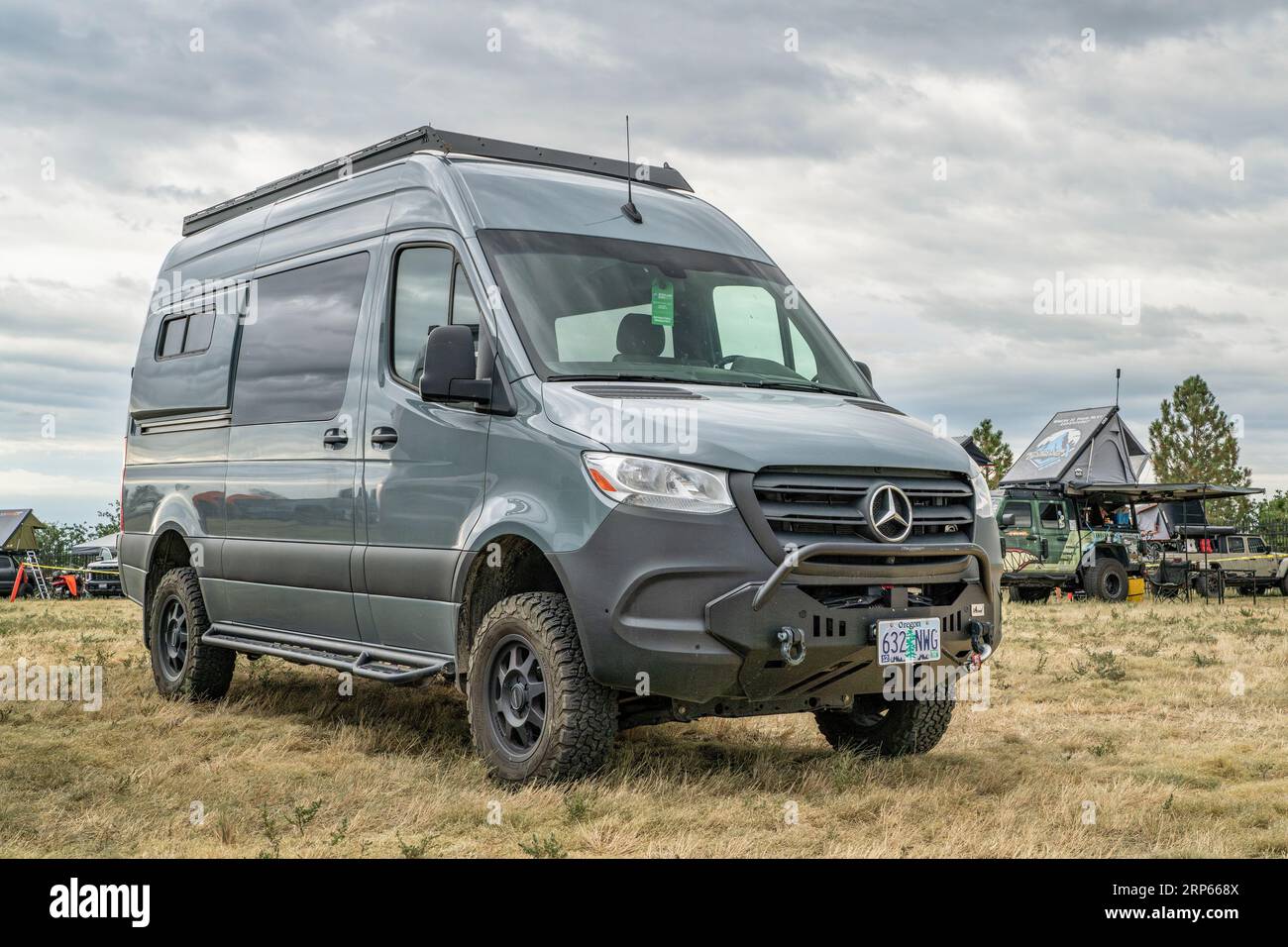 Loveland, CO, USA - August 25, 2023: 4x4 camper van on Mercedes Sprinter chassis with a custom front bumper and winch at a busy campground. Stock Photo