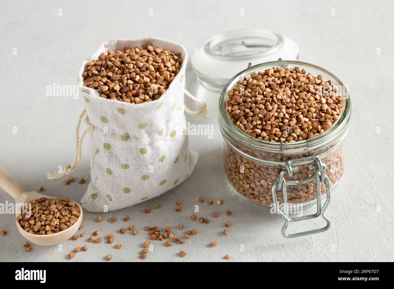 Raw buckwheat grain in a glass jar and cereals in a canvas bag on a