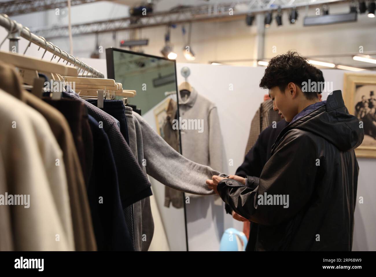 (190108) -- FLORENCE (ITALY), Jan. 8, 2019 -- A visitor looks at the products of a Japanese brand during the 95th Pitti Immagine Uomo exhibition in Florence, Italy, Jan. 8, 2019. The exhibition, one of the world s most important platforms for men s clothing and accessory collections, is held here from Jan. 8 to 11. ) ITALY-FLORENCE-MEN S CLOTHING AND ACCESSORY-EXHIBITION ChengxTingting PUBLICATIONxNOTxINxCHN Stock Photo