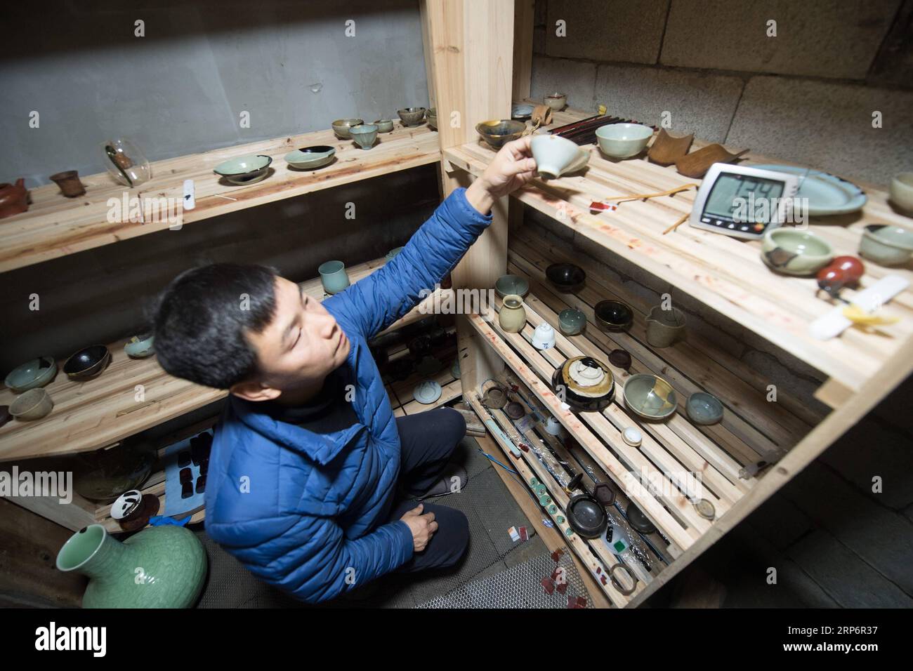 (190119) -- LONGQUAN, Jan. 19, 2019 (Xinhua) -- Wu Rongqiang checks dried lacquerwares at his studio in Niutouling Village, Longquan City of east China s Zhejiang Province, Jan. 15, 2019. Wu Rongqiang, a Longquan native aged 45, started exploring traditional lacquer art since 2012. In 2017, he moved his family to an old house deep in the mountains in Longquan in order to do more experiments in lacquer undisturbed. He uses lacquer to repair broken porcelain and to create lacquerware. Also, he experiments on the production of various lacquers. I feel so pleased to return to my hometown and do so Stock Photo