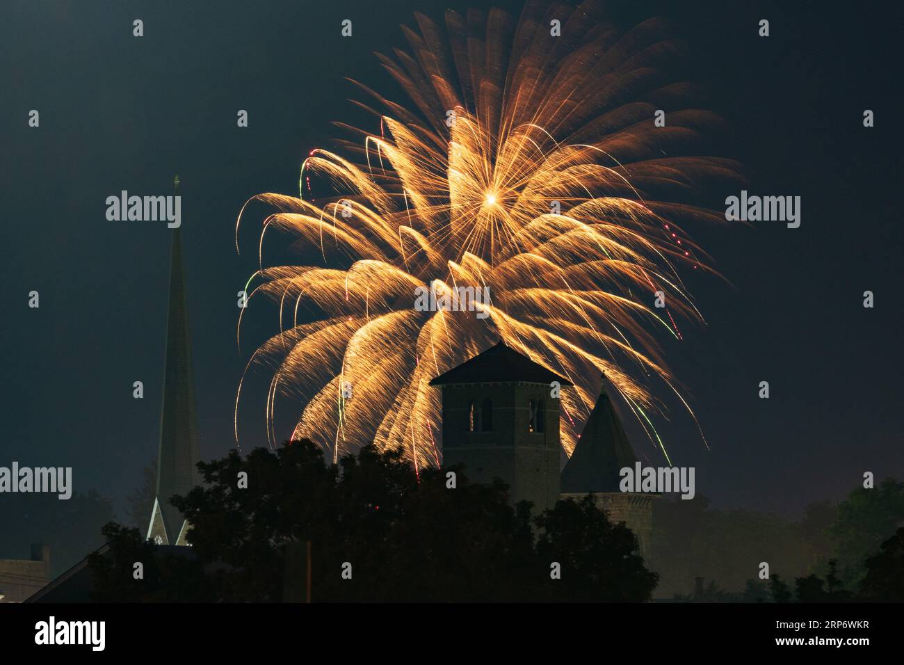 Fireworks explode over church steeples durng an Independence Day