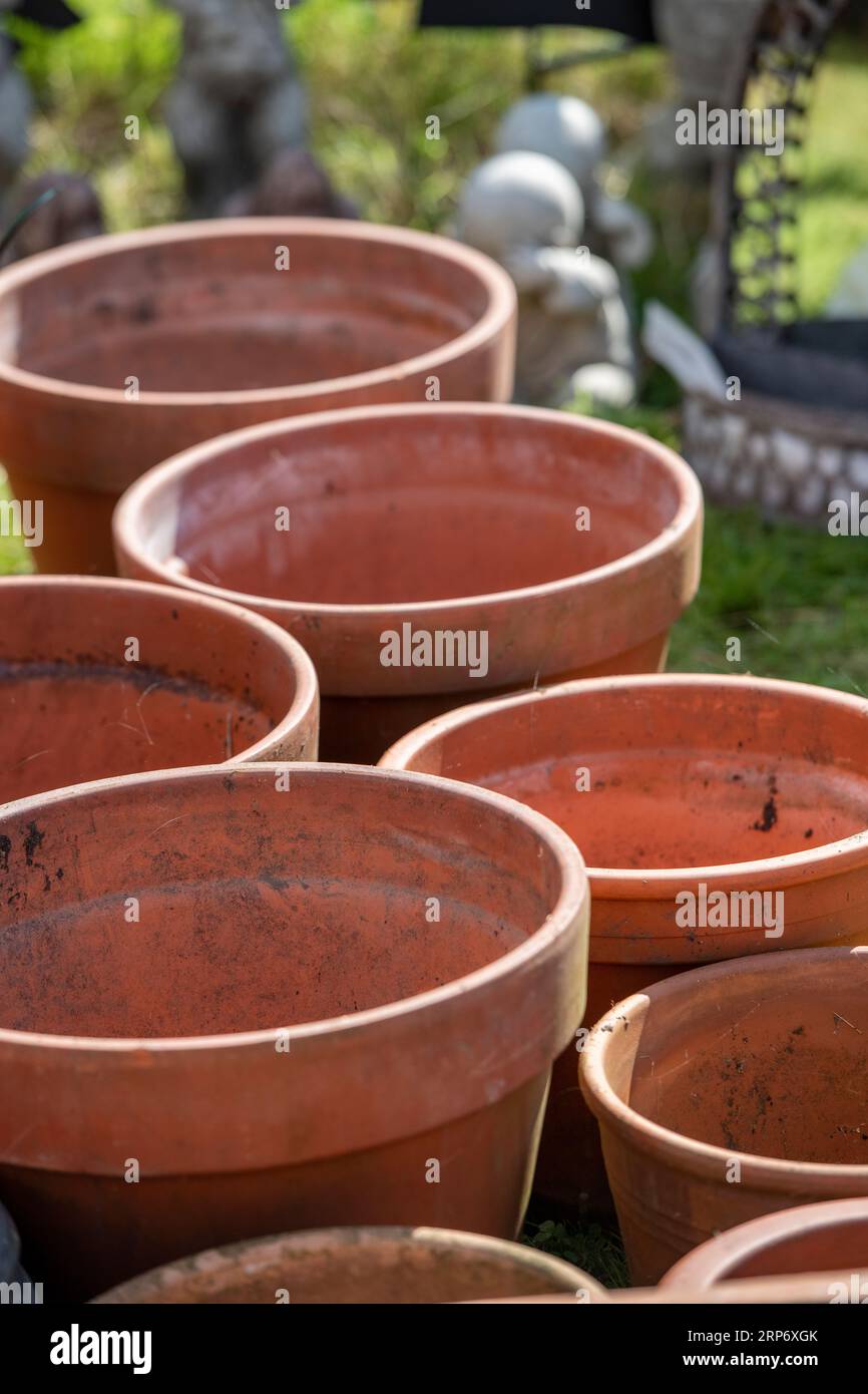 row of large terracotta plant pts or planters on sale at a garden centre.close-up of row of big planters for flowers or garden plants Stock Photo
