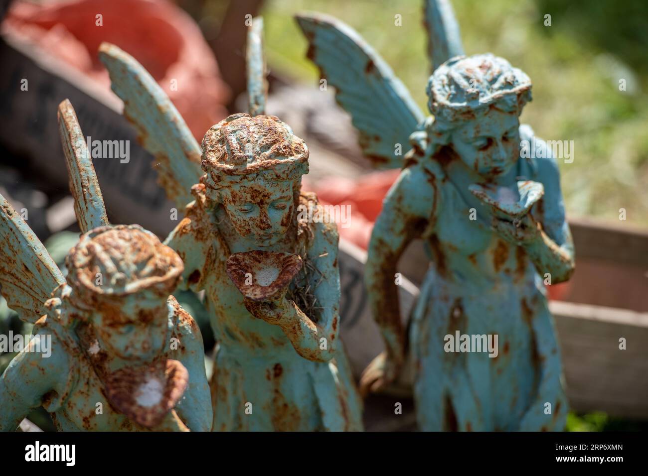 distressed metal garden ornaments on display at a garden centre. rusting and corroded female sculptures at a nursery or garden centre. Stock Photo