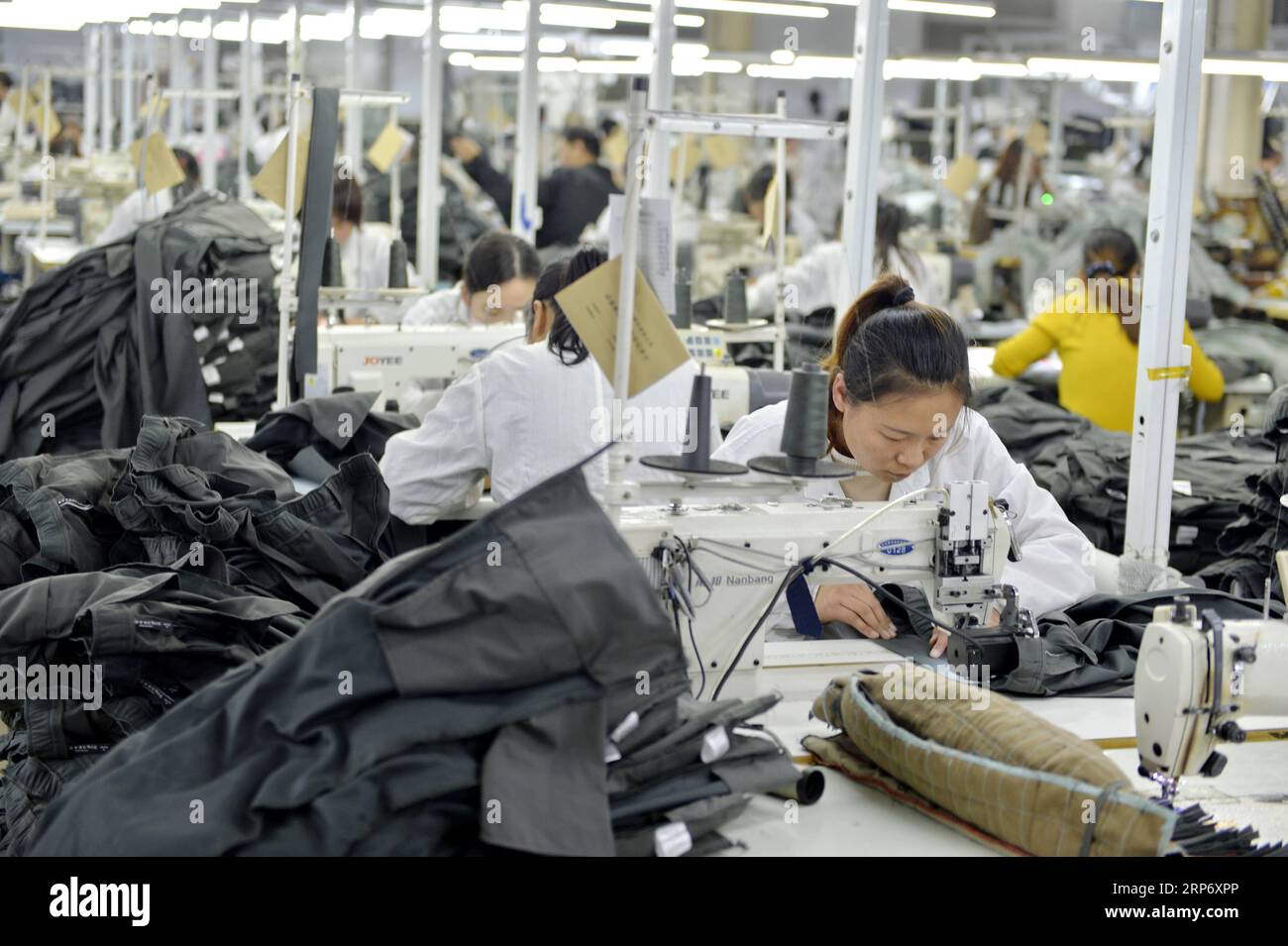 (190122) -- BEIJING, Jan. 22, 2019 (Xinhua) -- Workers sew clothes at a workshop of an enterprise in Ningjin County, north China s Heibei Province, Dec. 29, 2018. China s economy grew 6.6 percent year on year in 2018, beating the official annual target of around 6.5 percent, data from the National Bureau of Statistics (NBS) showed Monday. The country s gross domestic product (GDP) hit 90.03 trillion yuan (about 13.32 trillion U.S. dollars) in 2018. The following are a group of facts and figures released by the NBS on its solid economic performance last year. -- China s fixed-asset investment g Stock Photo