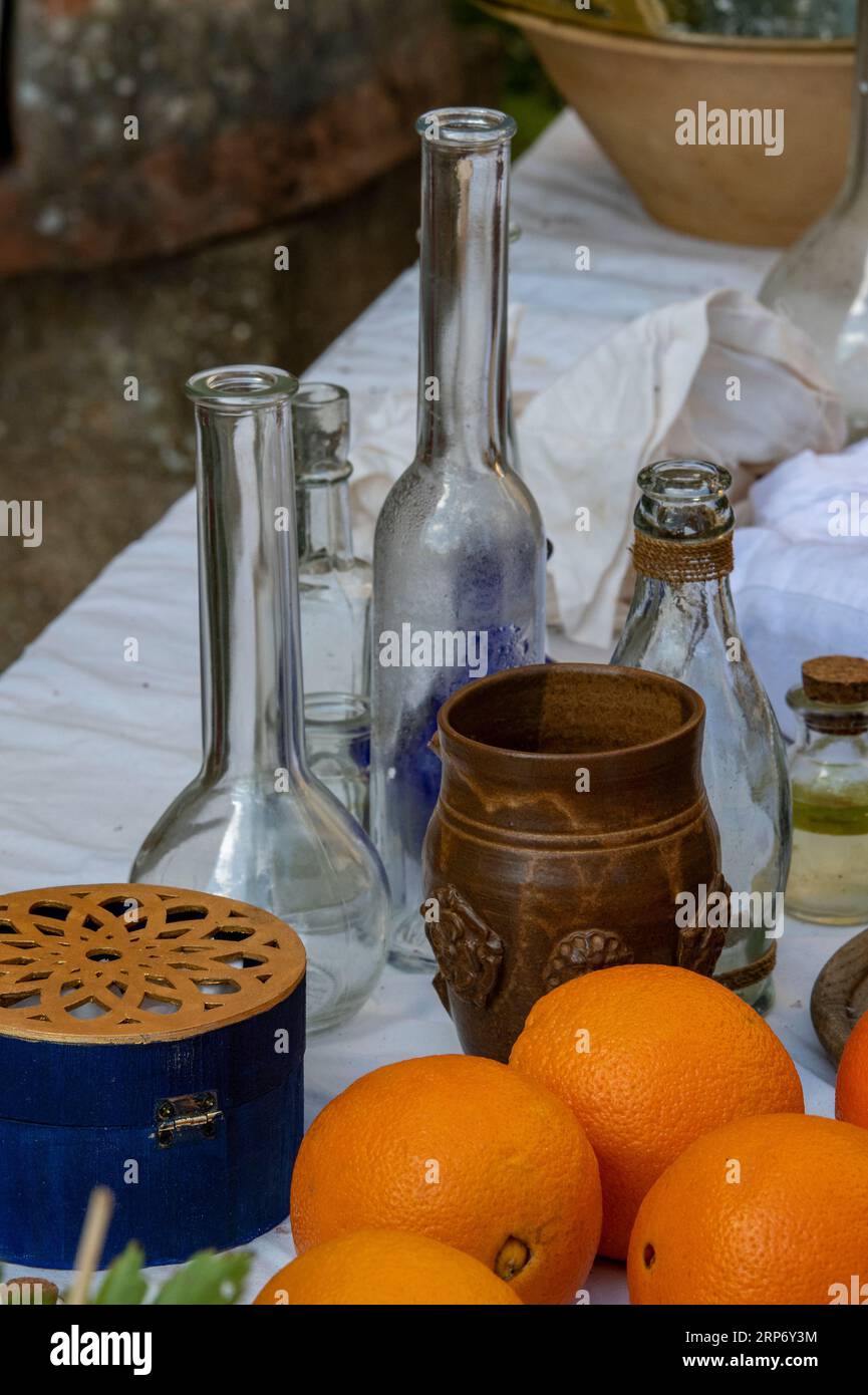 oranges and other ingredients on a table with jars and pots used by a chemist, cook or apothecary. mixing lotions and potions with herbs and spices. Stock Photo