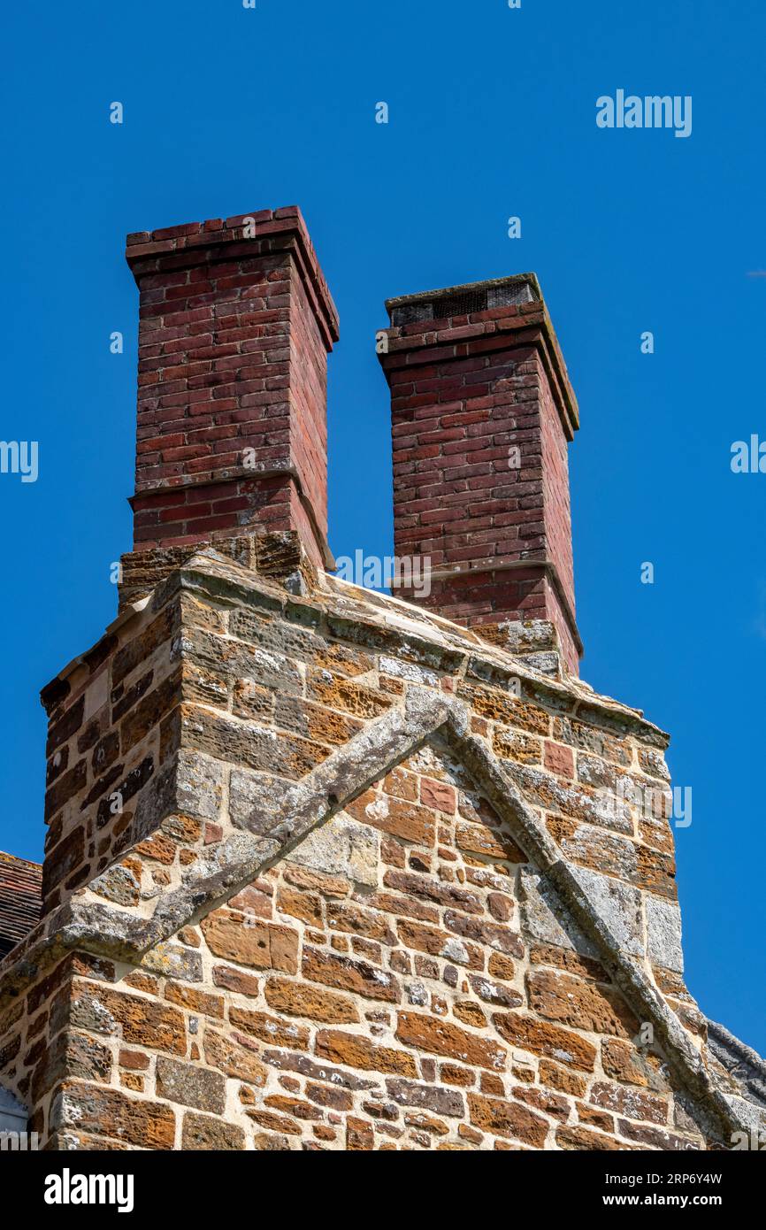 hexagonal red brick chimney pots on the roof of a tudor country house on the isle of wight. Stock Photo