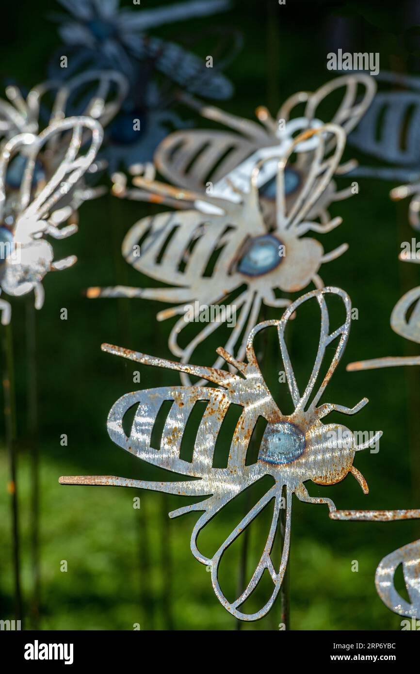 metal models or sculptures of bees at a garden centre for use as garden ornaments. Stock Photo