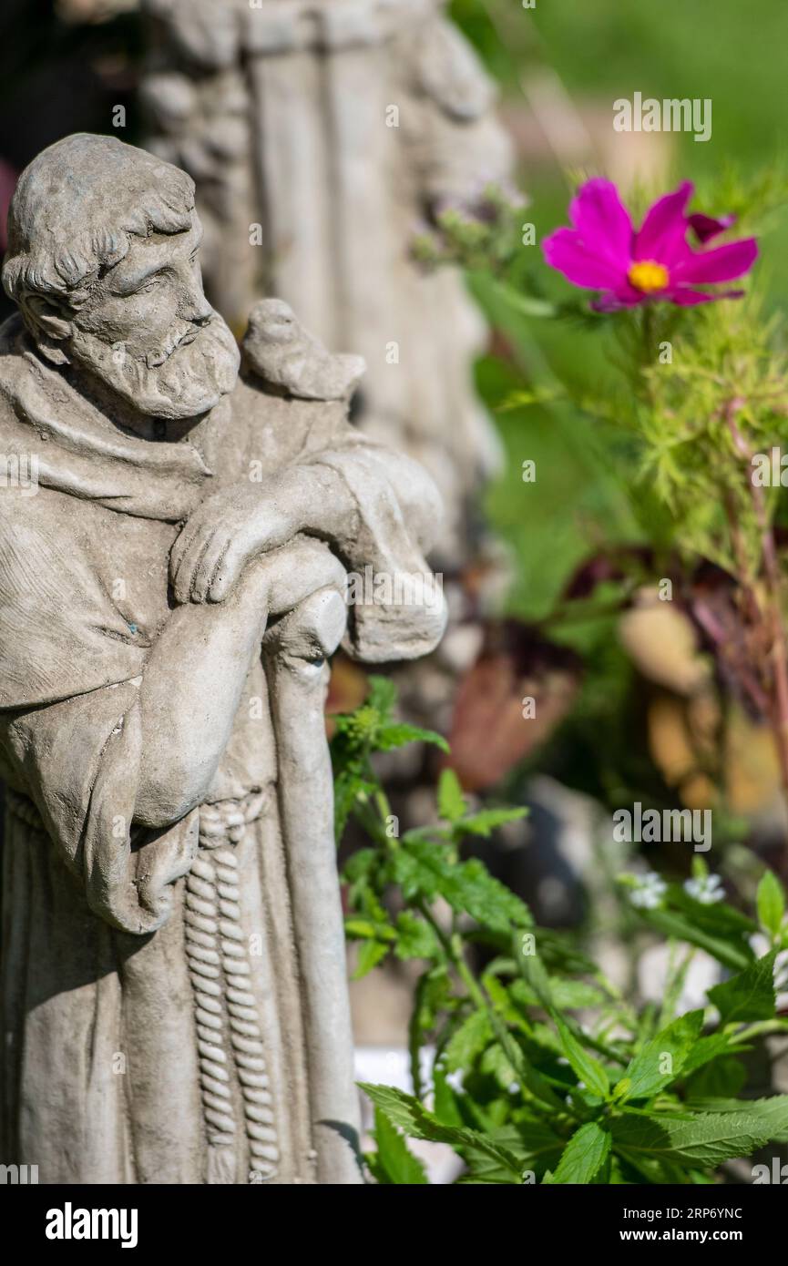 religious figure of a saint or herdsman made from stone or concrete. garden ornament decoration. Stock Photo