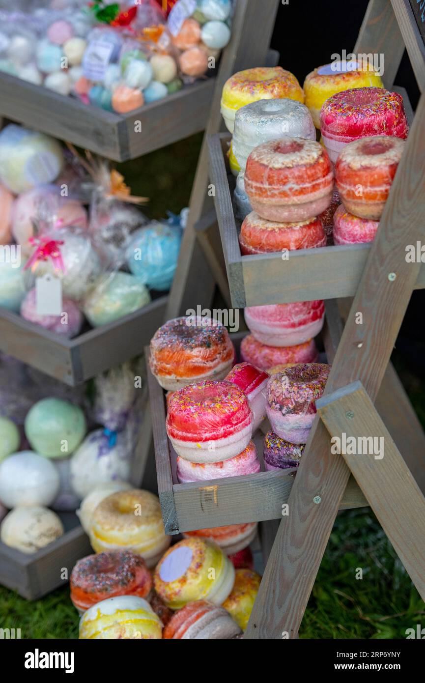 bath bombs, bath salts and foaming bath time cosmetics in different colours on sale in a cosmetics or chemist shop Stock Photo