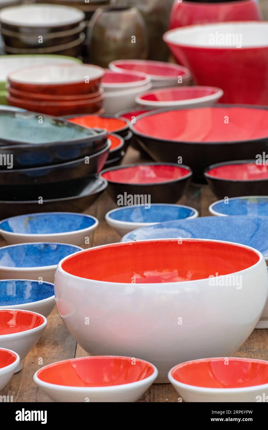 abstract image of colourful pottery or ceramic bowls stacked together on display at a cookery shop. Stock Photo