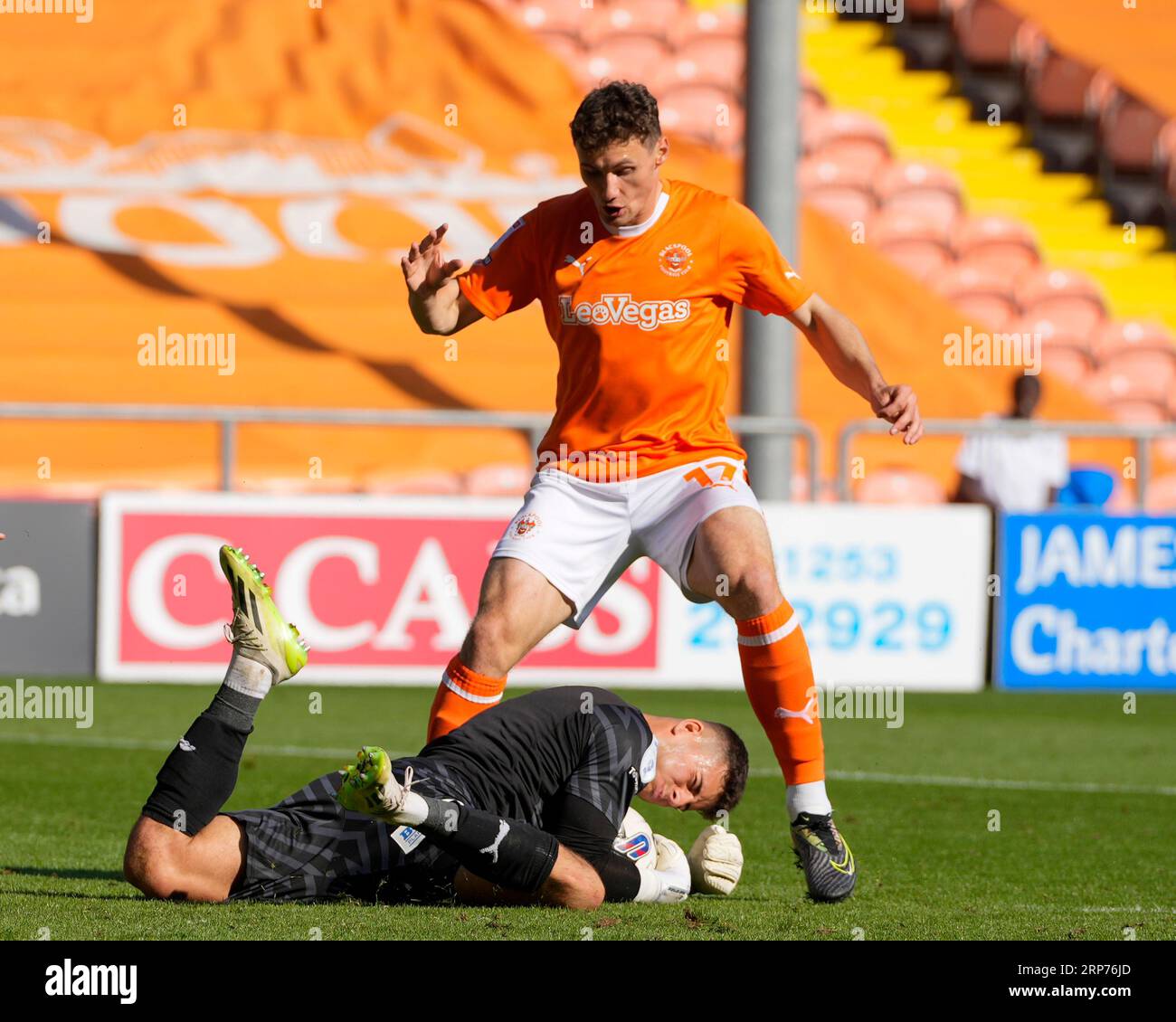 Sam Tickle #1 of Wigan Athletic dives at the feet of Matty Virtue #17 of Blackpool during the Sky Bet League 1 match Blackpool vs Wigan Athletic at Bloomfield Road, Blackpool, United Kingdom, 2nd September 2023  (Photo by Steve Flynn/News Images) Stock Photo