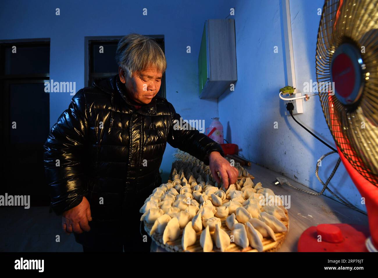 (190129) -- WENXI COUNTY, Jan. 29, 2019 (Xinhua) -- Bai Gaijiao, a resident of the Home of Happiness poverty-alleviation settlement, arranges freshly-made dumplings in Zhangcailing Village of Yangyu Township, Wenxi County, north China s Shanxi Province, Jan. 28, 2019. For generations, residents of Zhangcailing Village barely scraped a living as a result of geographical isolation, poor infrastructure and lack of supporting industries. To help pull villagers out of poverty, the government increased its financial support encouraging agriculture and husbandry suited to the local conditions. By pla Stock Photo