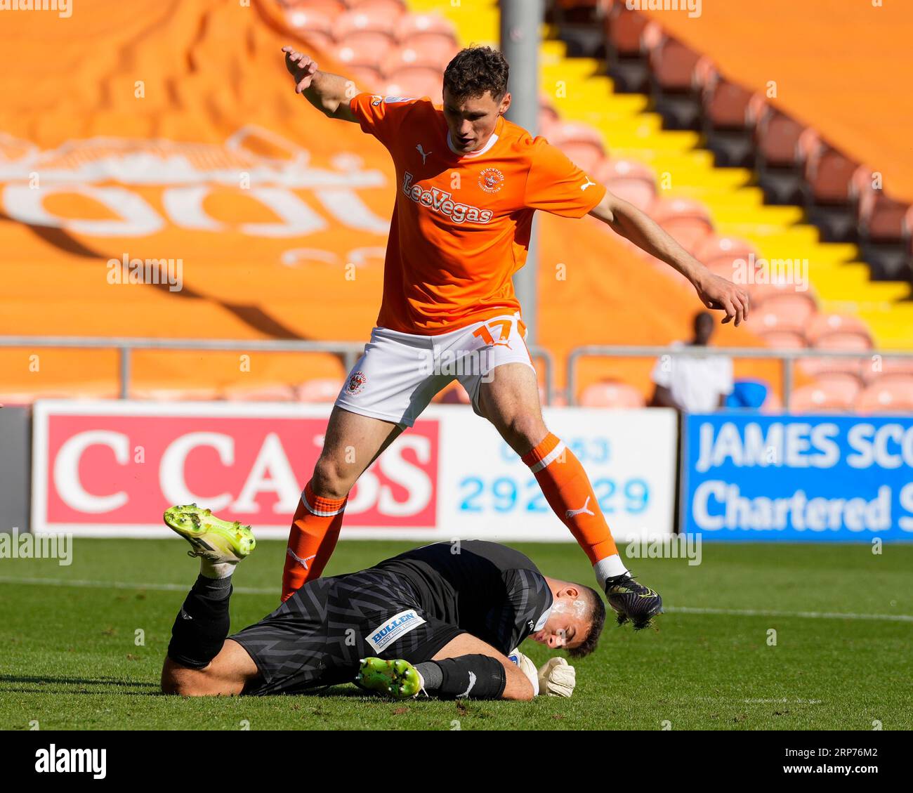 Sam Tickle #1 of Wigan Athletic dives at the feet of Matty Virtue #17 of Blackpool during the Sky Bet League 1 match Blackpool vs Wigan Athletic at Bloomfield Road, Blackpool, United Kingdom, 2nd September 2023  (Photo by Steve Flynn/News Images) Stock Photo