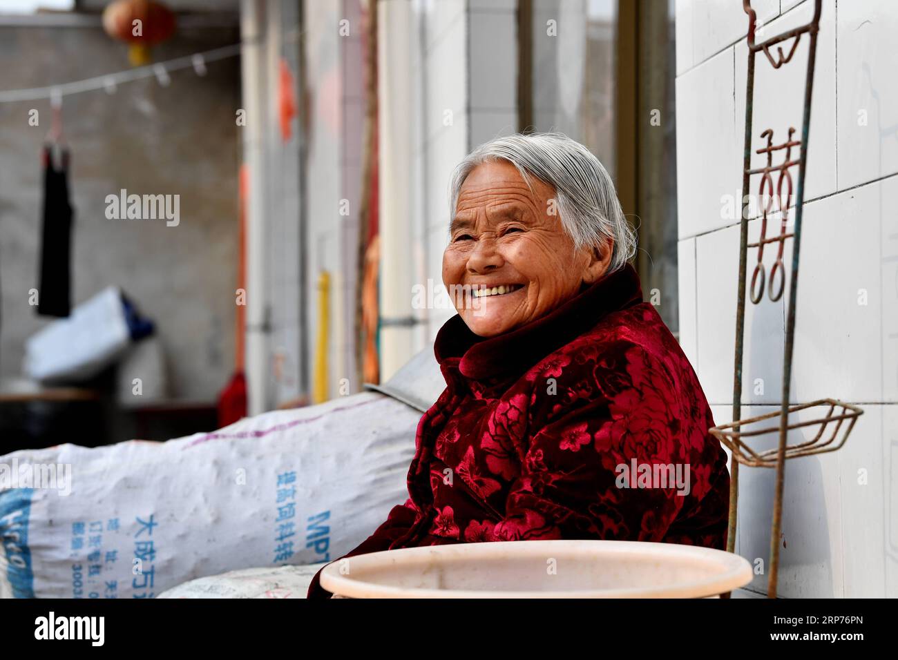 (190129) -- WENXI COUNTY, Jan. 29, 2019 (Xinhua) -- Zhai Xianying, a resident of the Home of Happiness poverty-alleviation settlement, takes a rest in Zhangcailing Village of Yangyu Township, Wenxi County, north China s Shanxi Province, Jan. 25, 2019. For generations, residents of Zhangcailing Village barely scraped a living as a result of geographical isolation, poor infrastructure and lack of supporting industries. To help pull villagers out of poverty, the government increased its financial support encouraging agriculture and husbandry suited to the local conditions. By planting Sichuan pep Stock Photo