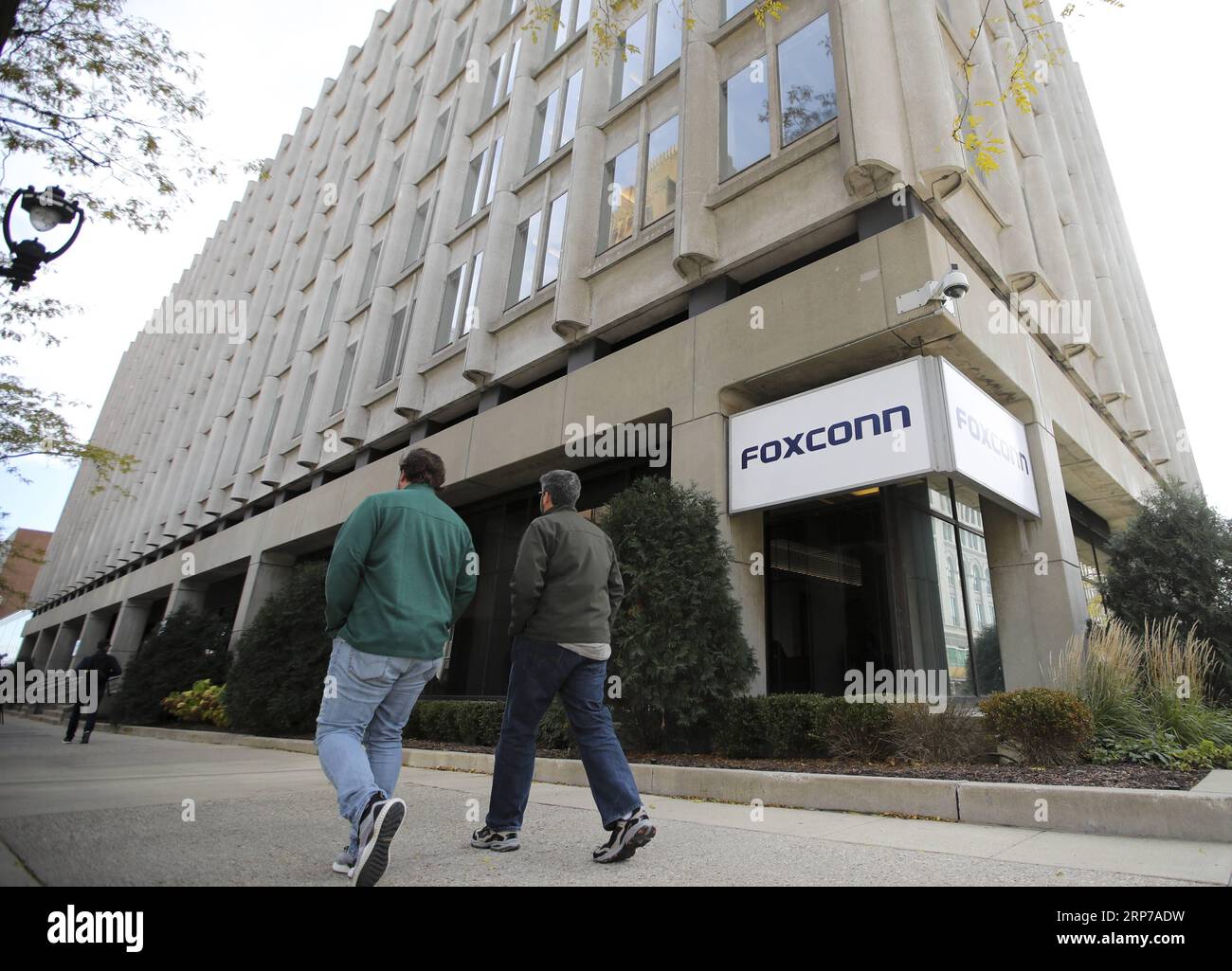 (190202) -- NEW YORK, Feb. 2, 2019 -- People walk past an office building of Foxconn in Milwaukee, Wisconsin, the United States, Nov. 2, 2018. Residents opposition, labor shortage, and technology transfer difficulties are the three main reasons why manufacturing companies like Foxconn could not move back to the United States easily, industry insiders and analysts have said. Being built on a vast 2,800 acres of land in the U.S. State of Wisconsin, the Foxconn plant project is dubbed by U.S. President Donald Trump as the eighth wonder of the world for the scale of investment, the number of new j Stock Photo