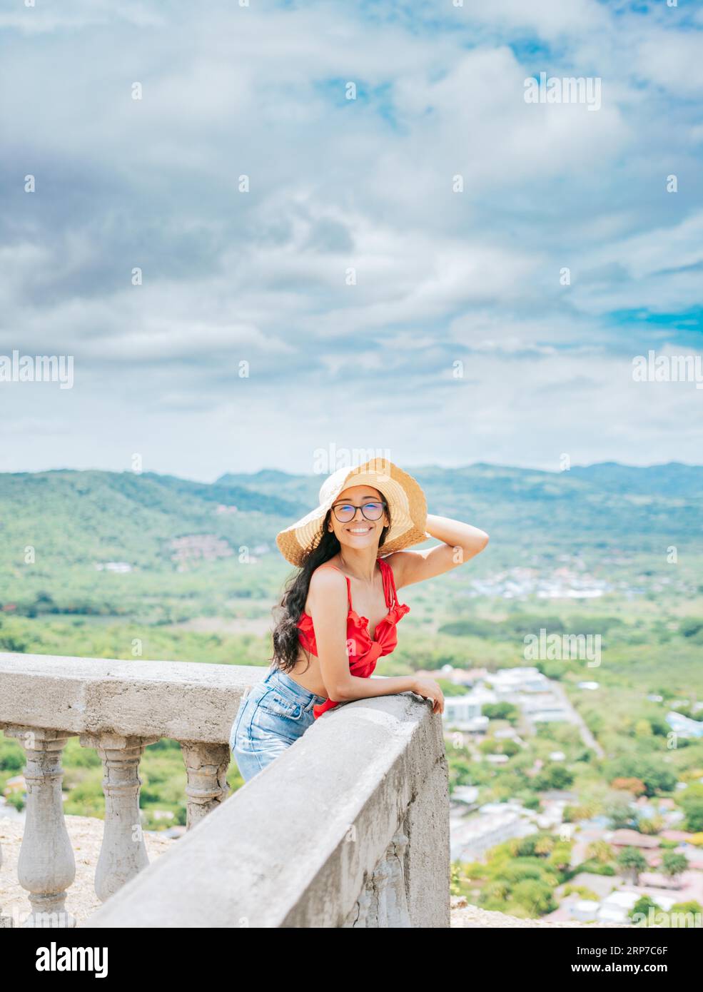 Happy tourist woman in hat on a viewpoint. Portrait of vacationer girl ...