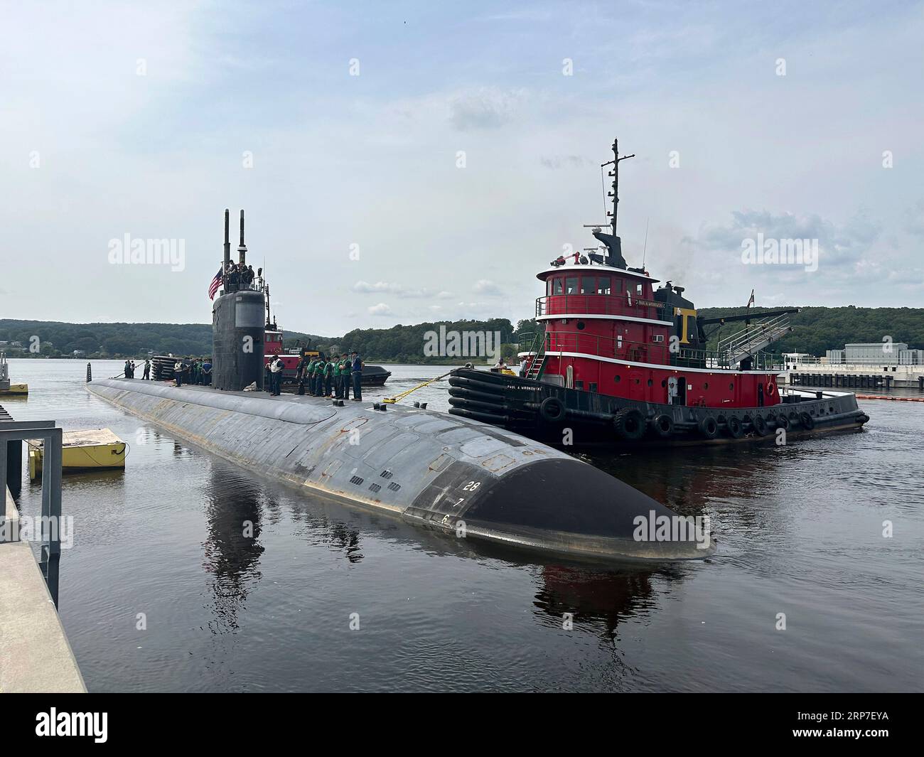Groton, United States. 21 August, 2023. The U.S. Navy Los Angeles-class fast attack submarine USS San Juan is assisted by a tug boat to dock for the final journey as it departs Naval Submarine Base New London, August 21, 2023 in Groton, Connecticut, USA. The San Juan was deployed for 35-years and will now begin the decommissioning process.  Credit: MCC Joshua Karsten/U.S. Navy/Alamy Live News Stock Photo