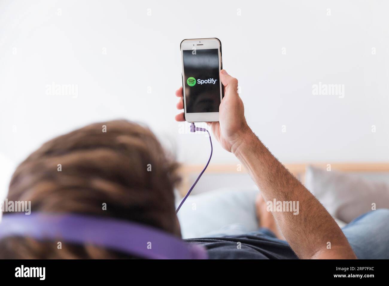 Young man holding smartphone with spotify app Stock Photo