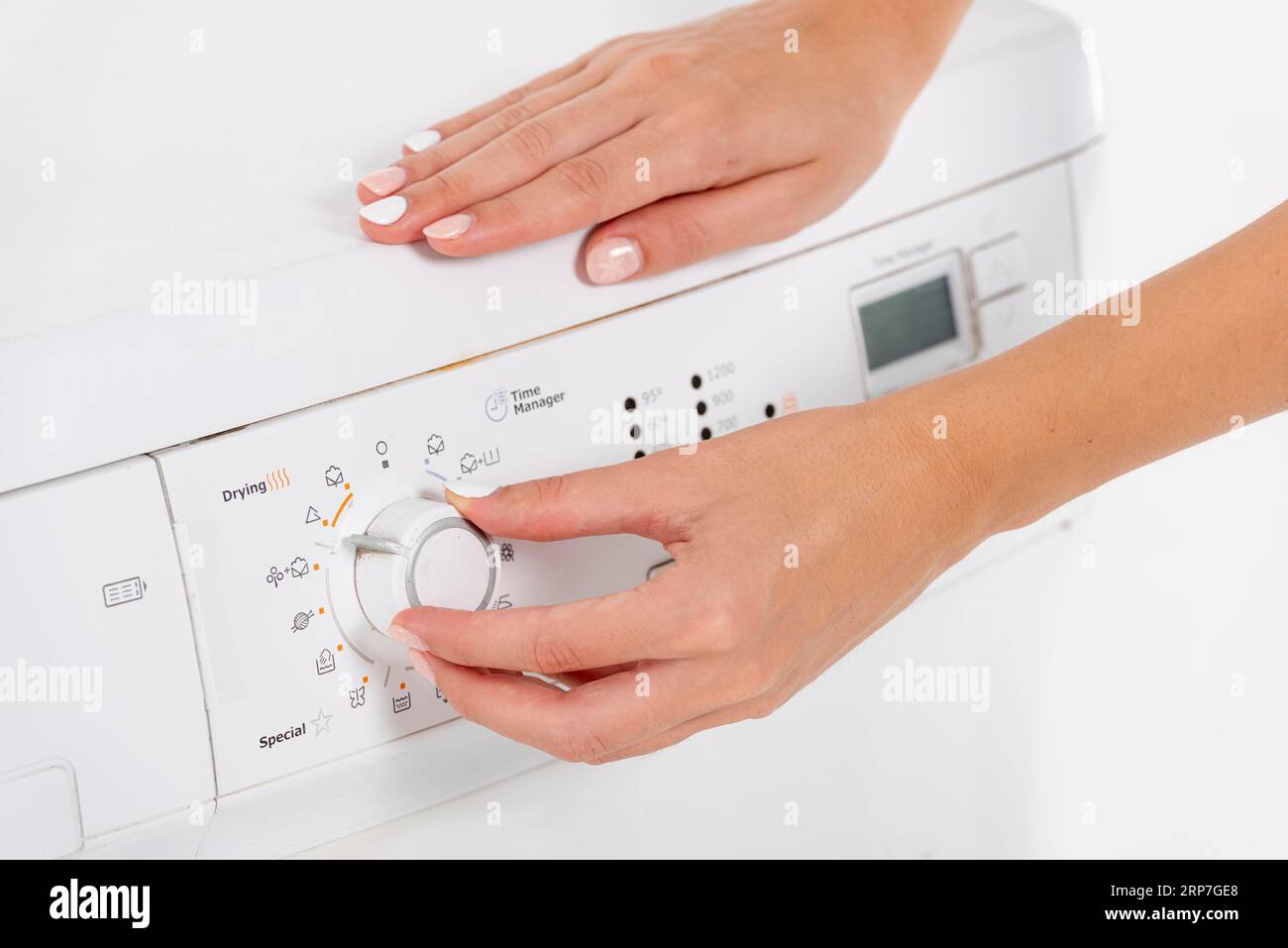 Woman programming washing machine Stock Photo Alamy