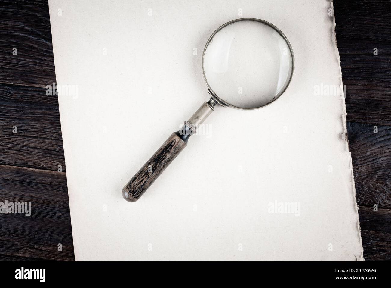 Antique vintage magnifying glass on paper background Stock Photo - Alamy
