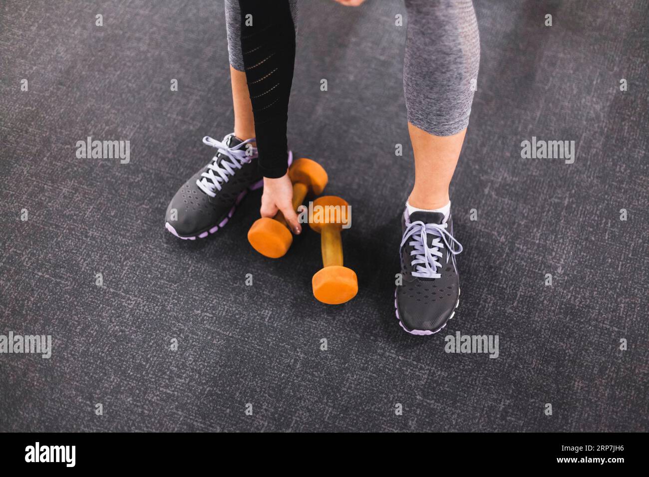 Low section view woman picking dumbbell gym Stock Photo