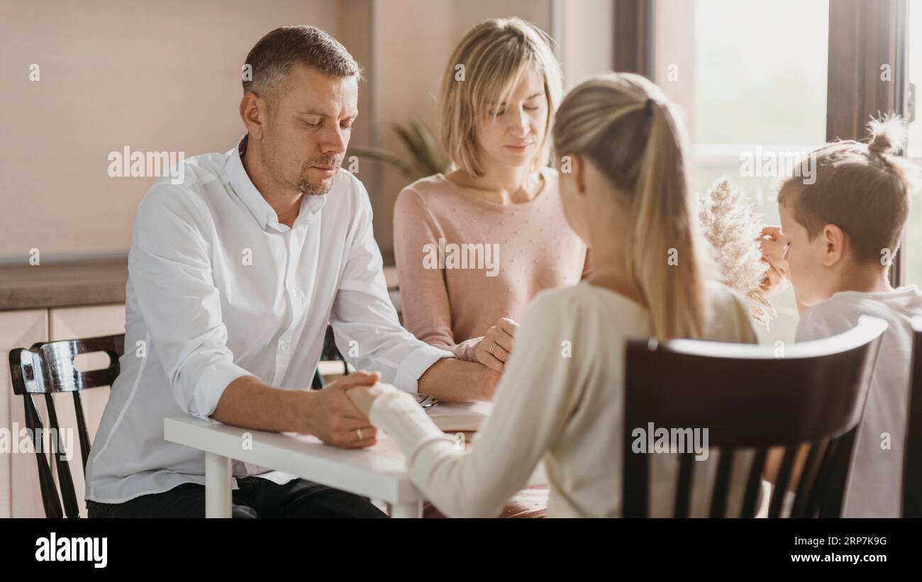 Beautiful family praying before eating Stock Photo - Alamy