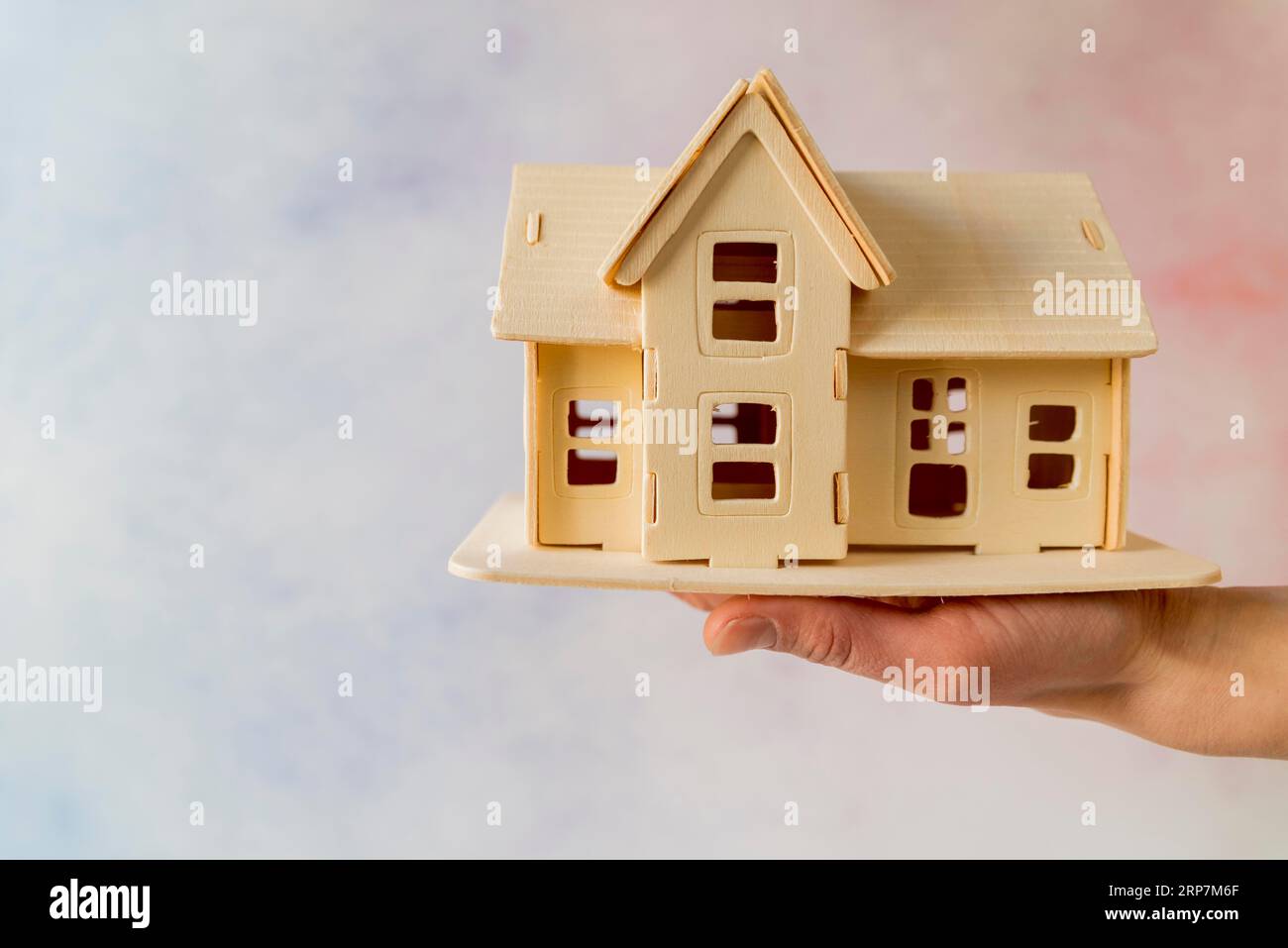 Close up hand holding house model against textured background Stock ...