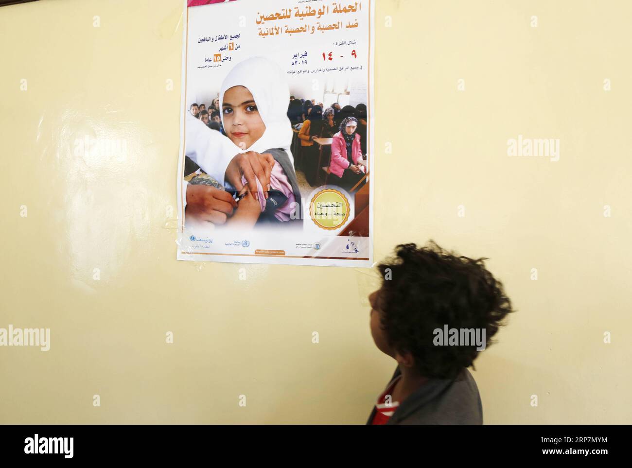 (190209) -- SANAA, Feb. 9, 2019 -- A child looks at an awareness poster before receiving an anti-measles and rubella vaccine in a school in Sanaa, Yemen, Feb. 9, 2019. A National Measles and Rubella Immunization Campaign kicked off on Saturday in Yemen and will last six days. The campaign targets Yemeni children from the age of six months to 15 years, according to the local media. Mohammed Mohammed) YEMEN-SANAA-MEASLES-RUBELLA-VACCINATION nieyunpeng PUBLICATIONxNOTxINxCHN Stock Photo