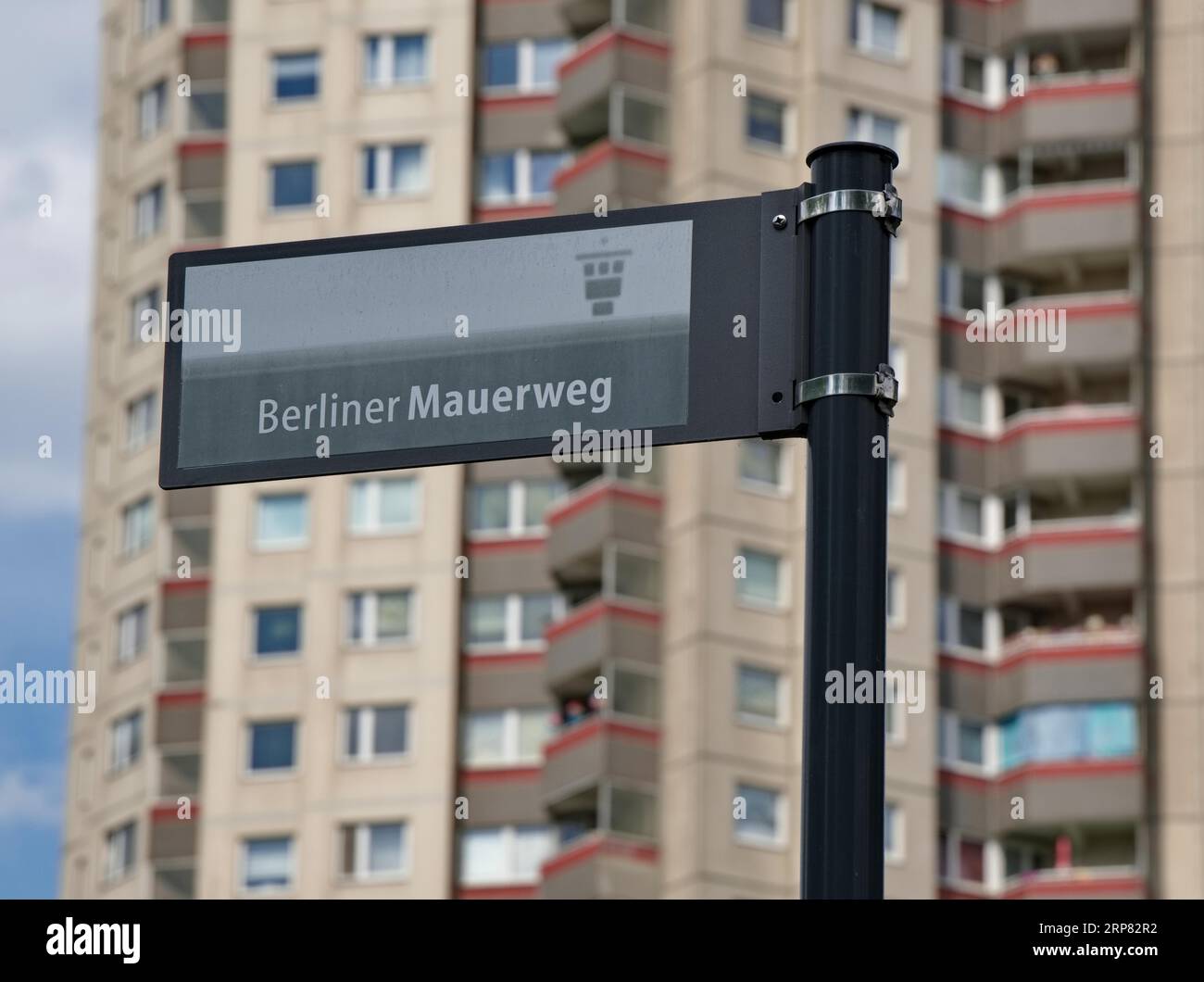 Sign with the inscription Berliner Mauerweg in front of a high-rise building in Gropiusstadt, Neukoelln district, Berlin, Germany Stock Photo