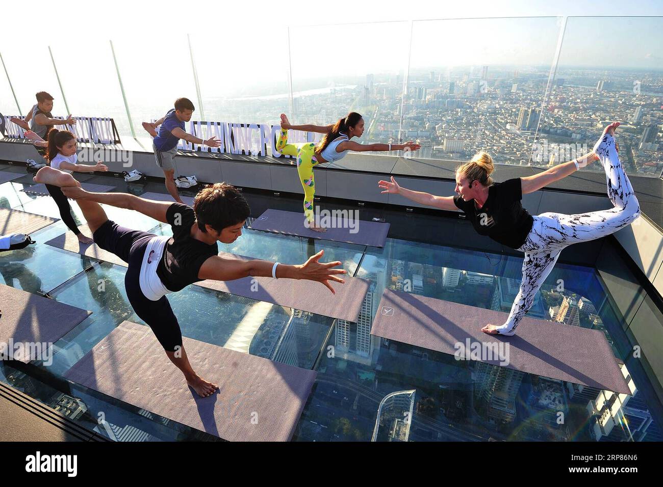 (190220) -- BEIJING, Feb. 20, 2019 (Xinhua) -- People practice yoga at an observation deck on the rooftop of a skyscraper in Bangkok, capital of Thailand, Feb. 19, 2019. (Xinhua/Rachen Sageamsak) XINHUA PHOTOS OF THE DAY PUBLICATIONxNOTxINxCHN Stock Photo
