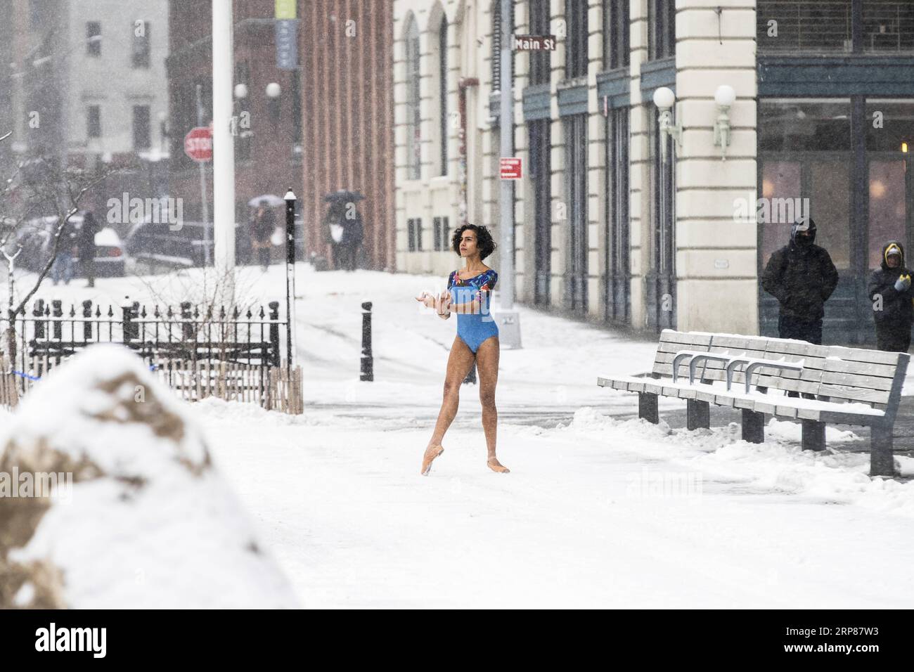 (190221) -- BEIJING, Feb. 21, 2019 -- A girl poses for photos in snow near the Brooklyn Bridge in New York, the United States, Feb. 20, 2019. More than 1,000 flights were canceled in airports across the United States Wednesday as a snow storm hit the east coast, including major cities of New York, Philadelphia and Washington D.C. ) XINHUA PHOTOS OF THE DAY WangxYing PUBLICATIONxNOTxINxCHN Stock Photo