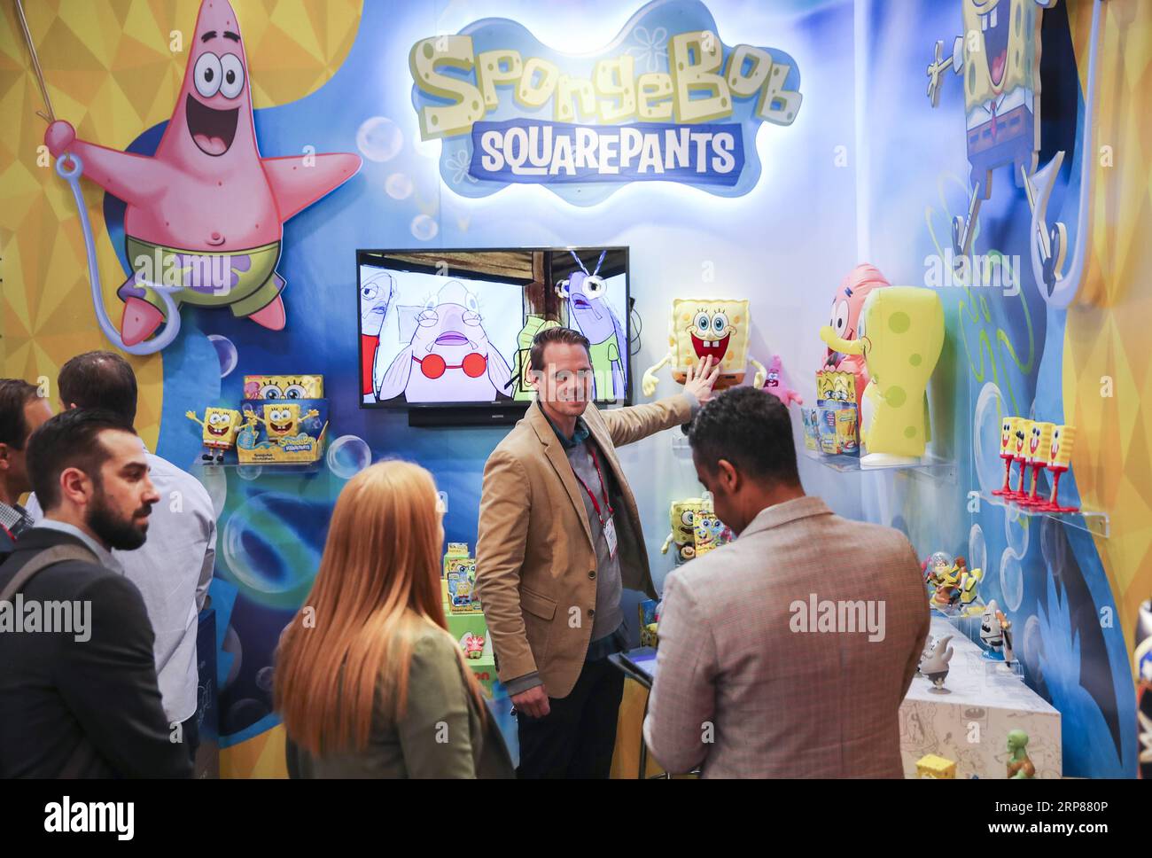 (190221) -- NEW YORK, Feb. 21, 2019 -- Visitors look at toy products of SpongeBob at the booth of Alpha Group Co., Ltd., a major animation, toy and entertainment player from Guangdong Province in southern China, during the 116th Annual North American International Toy Fair at the Jacob K. Javits Convention Center in New York, the United States, on Feb. 19, 2019. Chinese toy manufacturers, which produce around 75 percent of global toys each year, are rising up the value chain from the original role as contract manufacturers to designers and makers of their own brands. ) U.S.-NEW YORK-CHINESE TO Stock Photo
