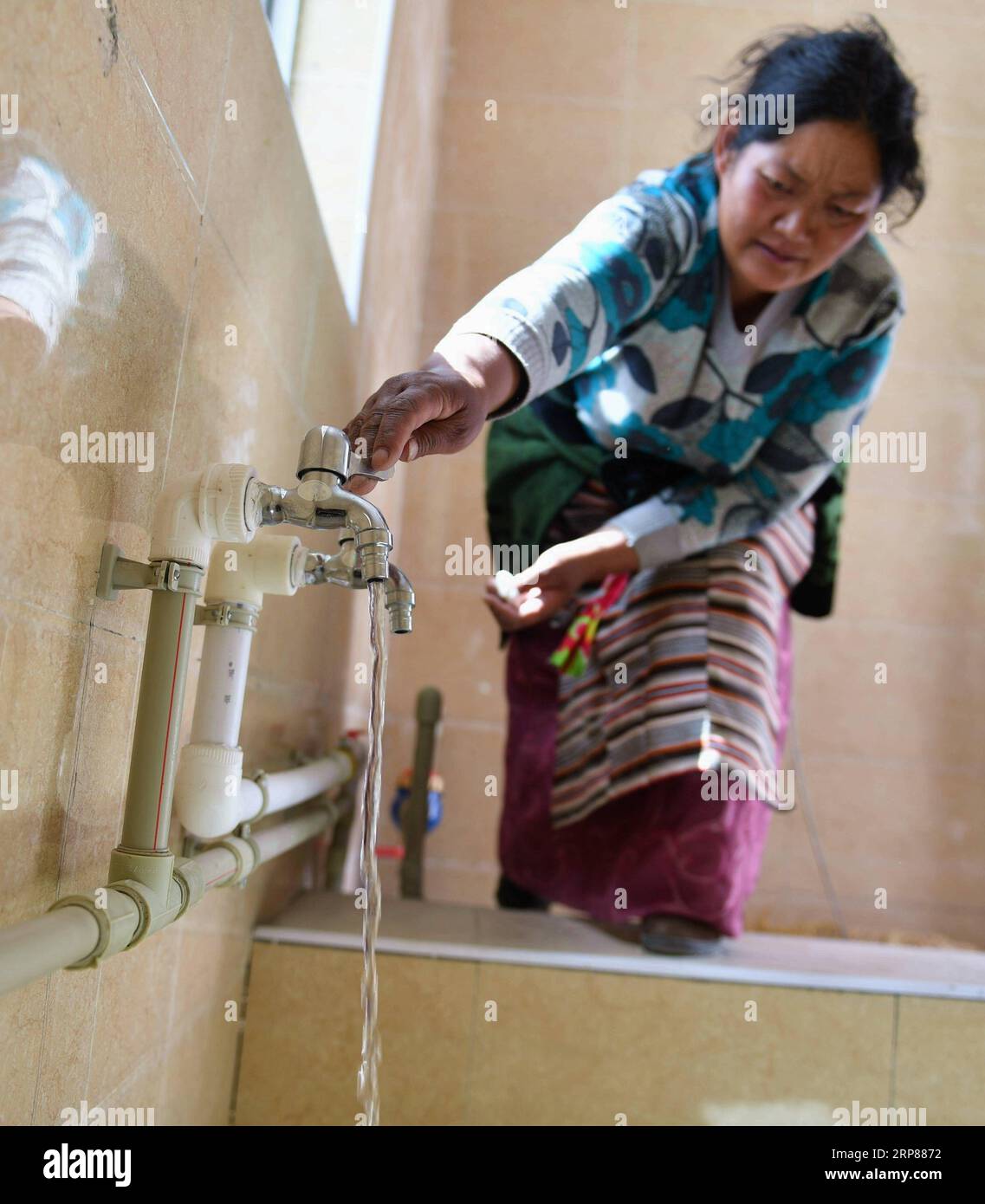 (190221) -- BEIJING, Feb. 21, 2019 -- A relocated resident pours water into a hot spring pool in Yangbajing Town of Damxung County in Lhasa, southwest China s Tibet Autonomous Region, Sept. 28, 2017. China has made important and decisive achievements in poverty relief in the past six years, and will continue its efforts this year to lay a solid foundation for winning the battle against poverty by 2020, an official said Wednesday. In the past six years, China lifted 82.39 million rural poor out of poverty, with the rural poor population down from 98.99 million at the end of 2012 to 16.6 million Stock Photo
