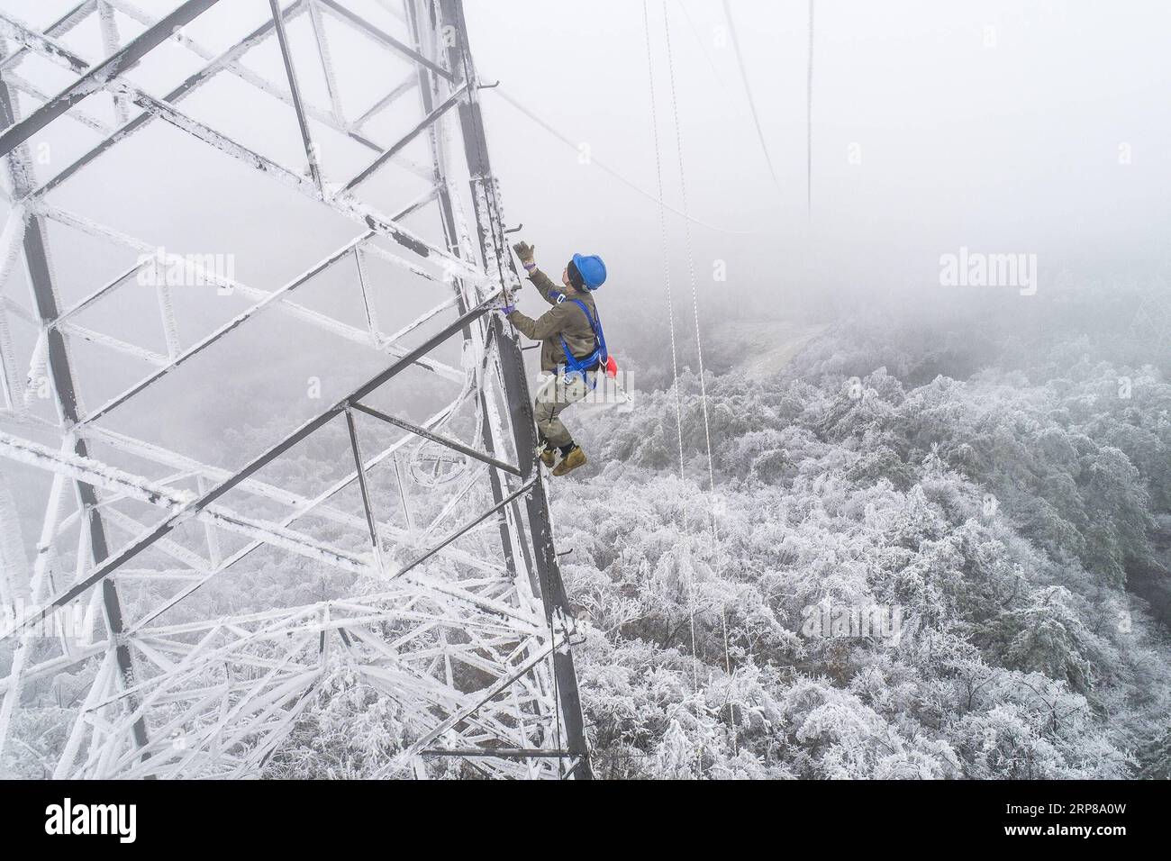 (190223) -- WUHAN, Feb. 23, 2019 -- Photo taken on Feb. 12, 2019 shows electrician Wang Chaolin climbing the power transmission tower for rush repairs in the mountain area of Wuhan, capital of central China s Hubei Province. A team of electricians was dispatched to repair a high voltage wire that was broken due to thick layer of ice accumulation. After one day s work on the over 40-meter-high power transmission tower in bad weather condition, the team succeeded in fixing the failed power system that lowered the trains speed causing delay during the post-holiday travel peak. This year s Spring Stock Photo