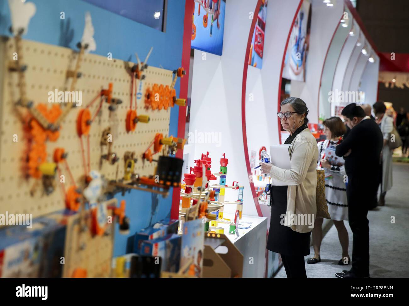(190226) -- BEIJING, Feb. 26, 2019 -- Visitors look at toy products at the booth of Hape Toys during the 116th Annual North American International Toy Fair at the Jacob K. Javits Convention Center in New York, the United States, on Feb. 18, 2019. ) Xinhua headlines: More fun toys, no painful tariffs: American toymakers hopeful on U.S.-China trade deal WangxYing PUBLICATIONxNOTxINxCHN Stock Photo
