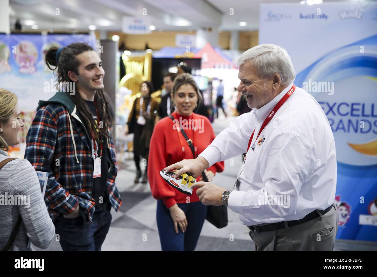 (190226) -- BEIJING, Feb. 26, 2019 -- Ken Silvestri (1st R), a staff worker of Choo Choo Shoes, shows the company s product to visitors at their booth during the 116th Annual North American International Toy Fair at the Jacob K. Javits Convention Center in New York, the United States, on Feb. 18, 2019. ) Xinhua headlines: More fun toys, no painful tariffs: American toymakers hopeful on U.S.-China trade deal WangxYing PUBLICATIONxNOTxINxCHN Stock Photo