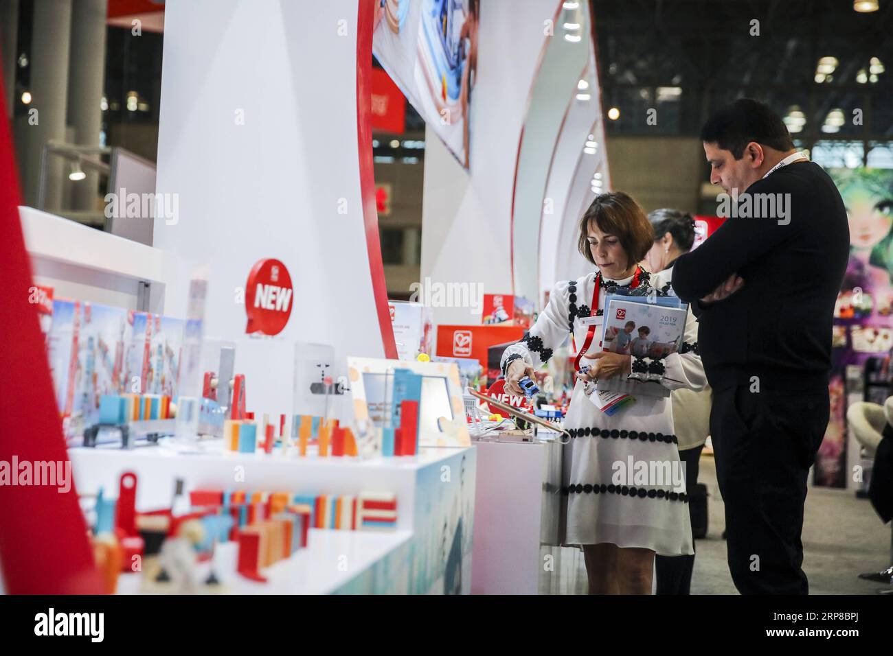 (190226) -- BEIJING, Feb. 26, 2019 -- Visitors look at toy products at the booth of Hape Toys during the 116th Annual North American International Toy Fair at the Jacob K. Javits Convention Center in New York, the United States, on Feb. 18, 2019. ) Xinhua headlines: More fun toys, no painful tariffs: American toymakers hopeful on U.S.-China trade deal WangxYing PUBLICATIONxNOTxINxCHN Stock Photo