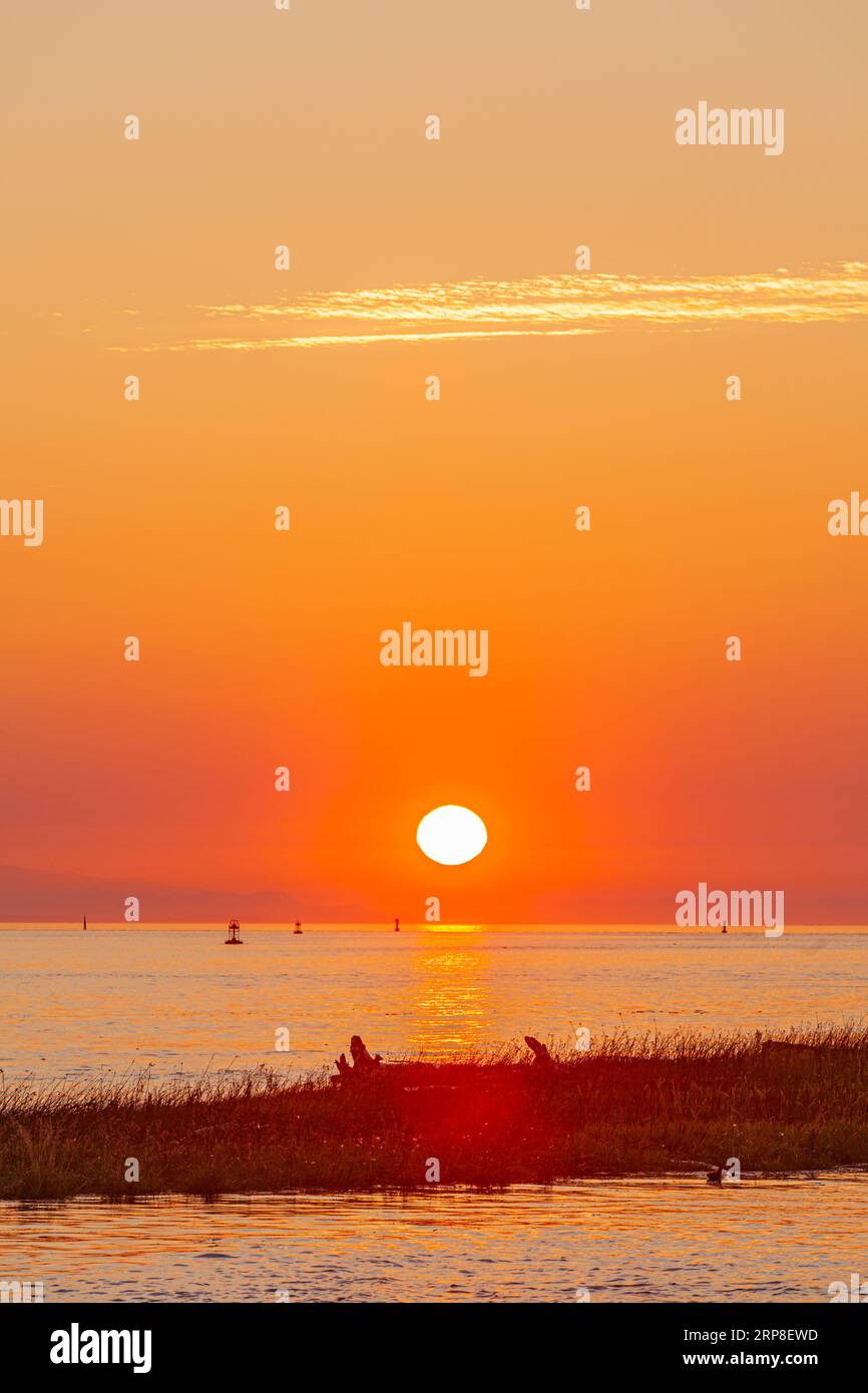 The sun setting over Vancouver Island as seen from Steveston in British Columbia Canada Stock Photo