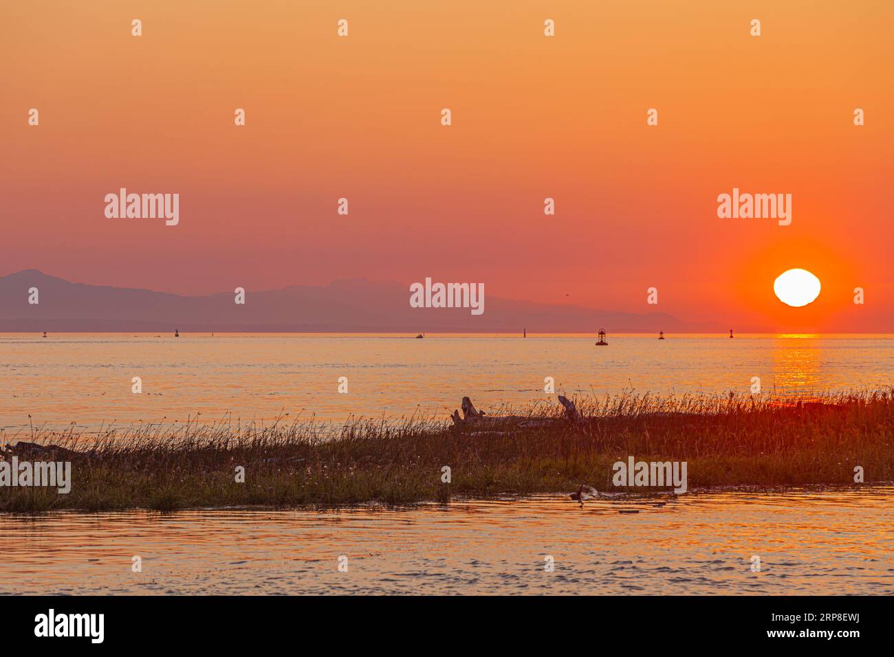 The sun setting over Vancouver Island as seen from Steveston in British Columbia Canada Stock Photo