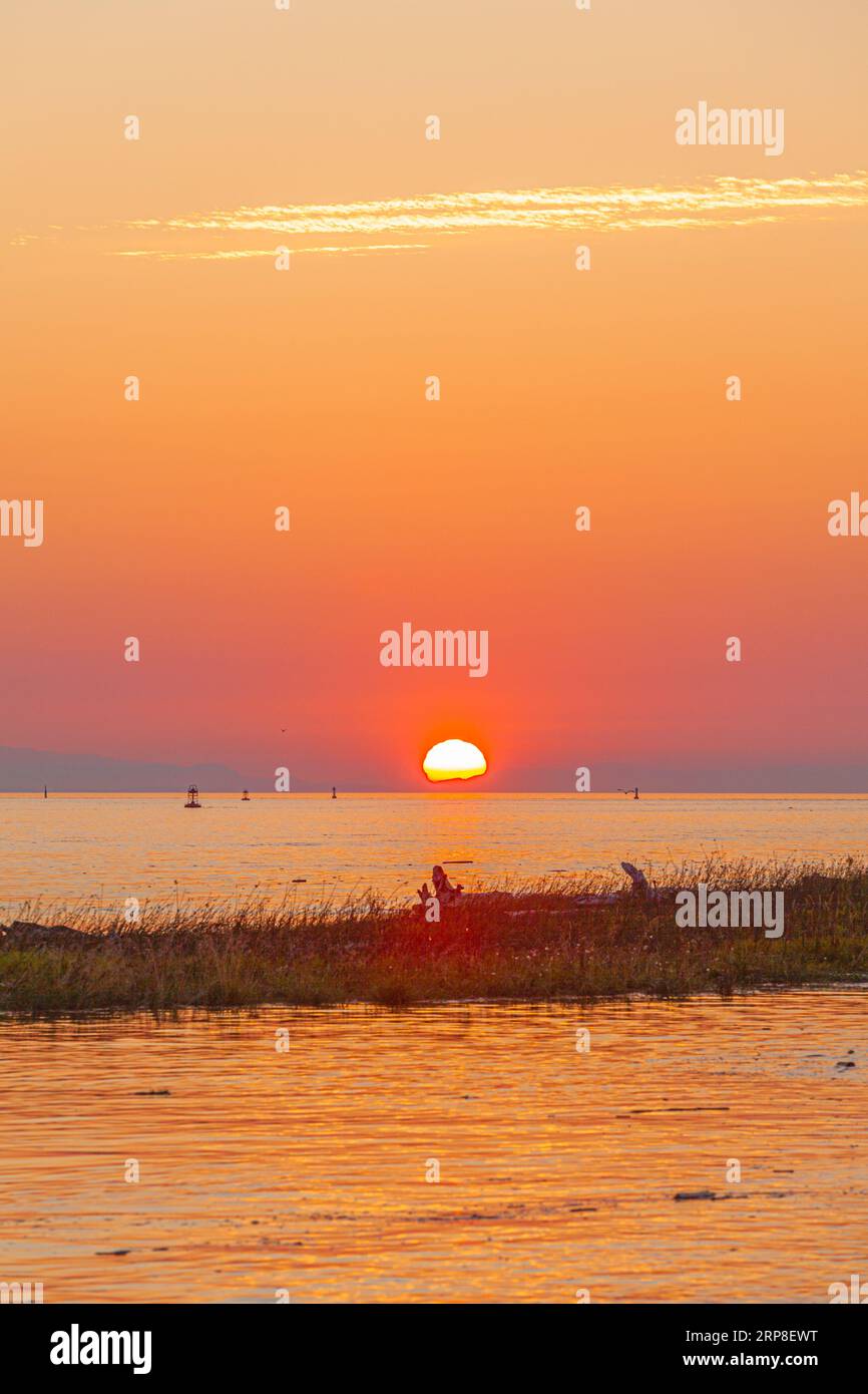 The sun setting over Vancouver Island as seen from Steveston in British Columbia Canada Stock Photo