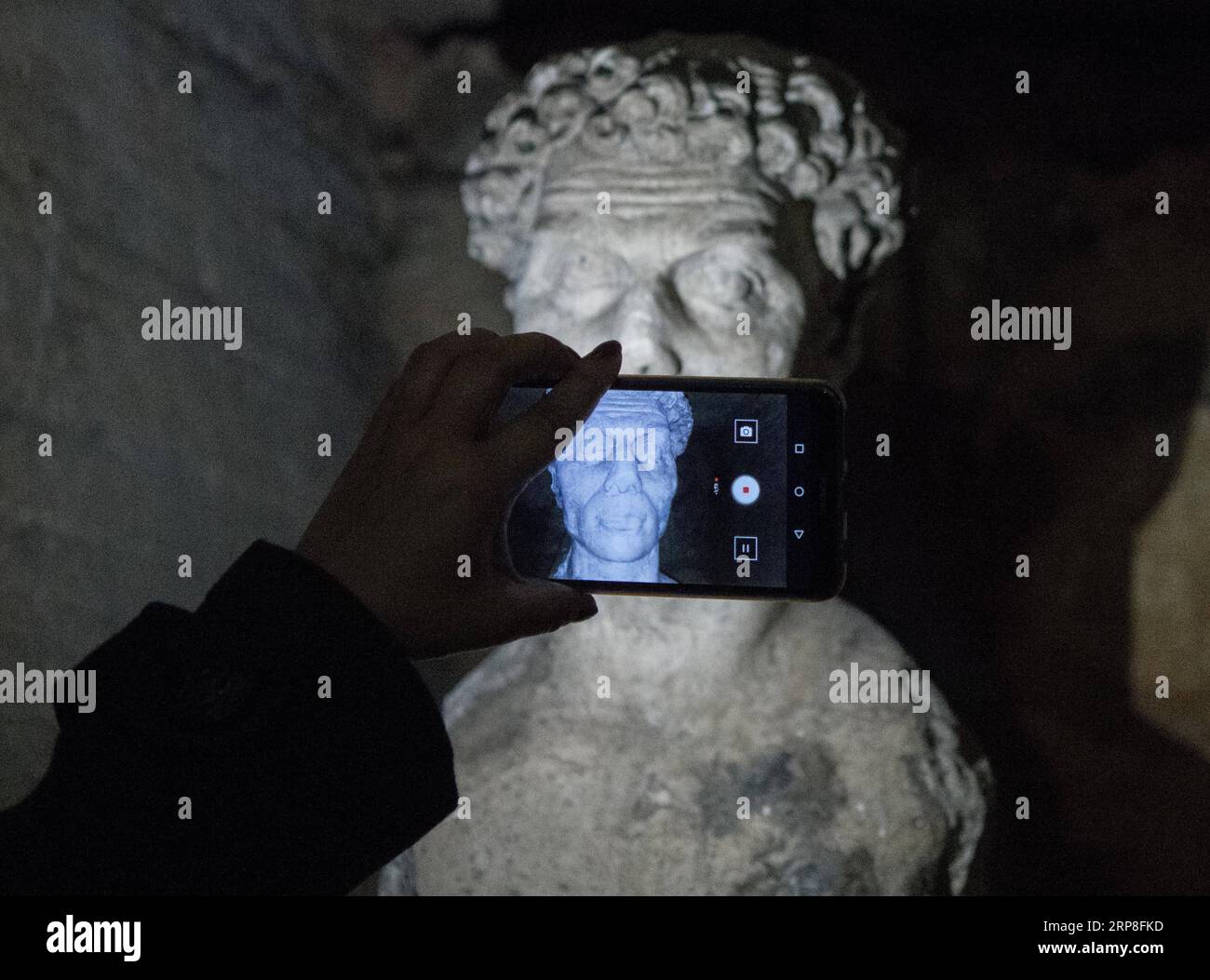 (190303) -- ALEXANDRIA (EGYPT), March 3, 2019 -- A man takes photos in ancient Kom al-Shoqafa tombs in the northern seaside Alexandria province, Egypt, on March 3, 2019. The Egyptian Ministry of Antiquities celebrated on Sunday the completion of a project removing underground water from 2,000-year-old catacombs in the northern seaside province of Alexandria dating back to the Greco-Roman era. ) EGYPT-ALEXANDRIA-GRECO-ROMAN CATACOMBS WuxHuiwo PUBLICATIONxNOTxINxCHN Stock Photo