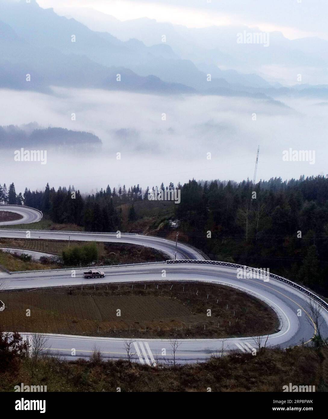 (190304) -- ENSHI, March 4, 2019 (Xinhua) -- Aerial photo taken on March 4, 2019 shows a car driving on the Shidaguai highway in Enshi, central China s Hubei Province. The Shidaguai highway, literally meaning highway with ten great curves in Chinese, is a section on the highway linking Baiyangping in central China s Hubei Province with Fengjie in southwest China s Chongqing. (Xinhua/Yang Shunpi) CHINA-HUBEI-ENSHI-HIGHWAY-CURVES (CN) PUBLICATIONxNOTxINxCHN Stock Photo