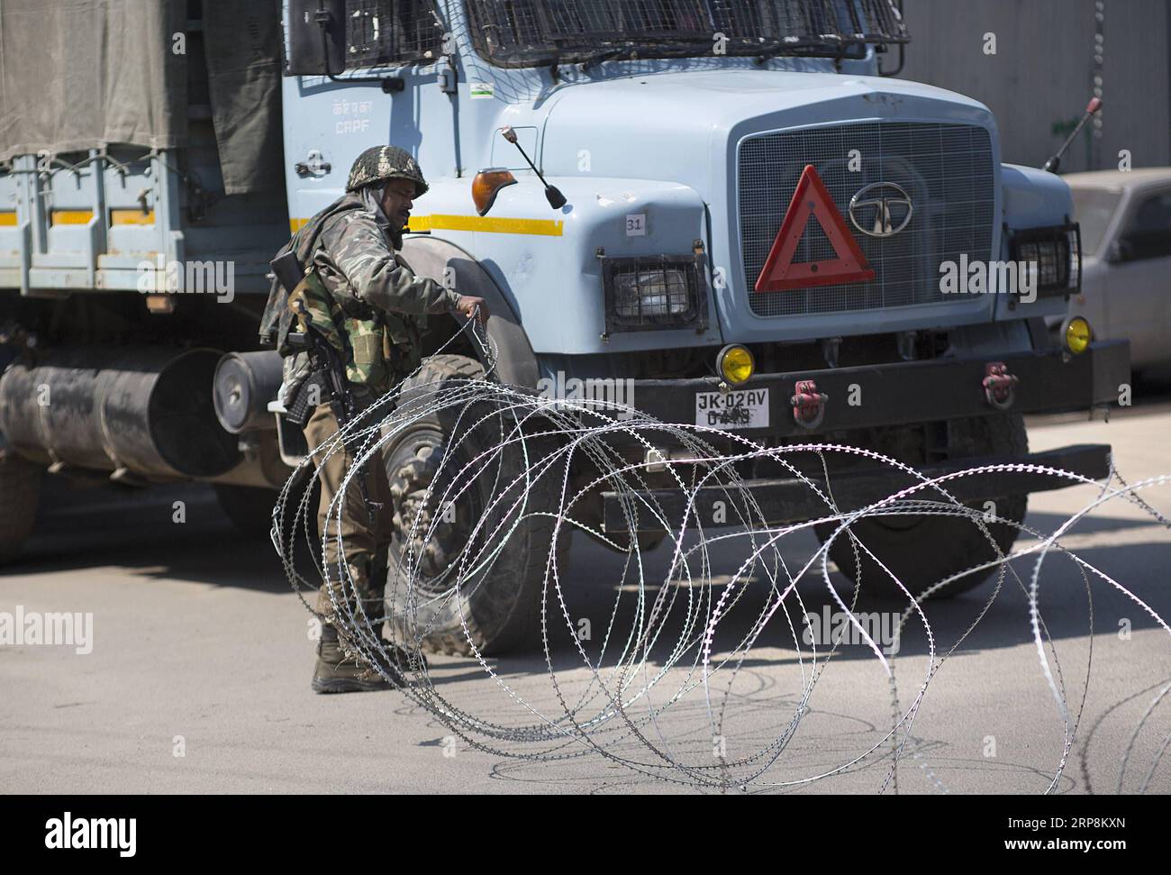 (190310) -- SRINAGAR, March 10, 2019 (Xinhua) -- An Indian paramilitary soldier lays barbed wire on a street during a security lockdown in downtown area of Srinagar, the summer capital of Indian-controlled Kashmir, March 10, 2019. Authorities on Sunday imposed restrictions in parts of Srinagar city to prevent protests after India s anti-terror agency, National Investigation Agency (NIA), summoned key separatist leader and chief cleric of Indian-controlled Kashmir for questioning in an alleged funding case, officials said on Saturday. Mirwaiz Umar Farooq has been asked to appear before the prob Stock Photo