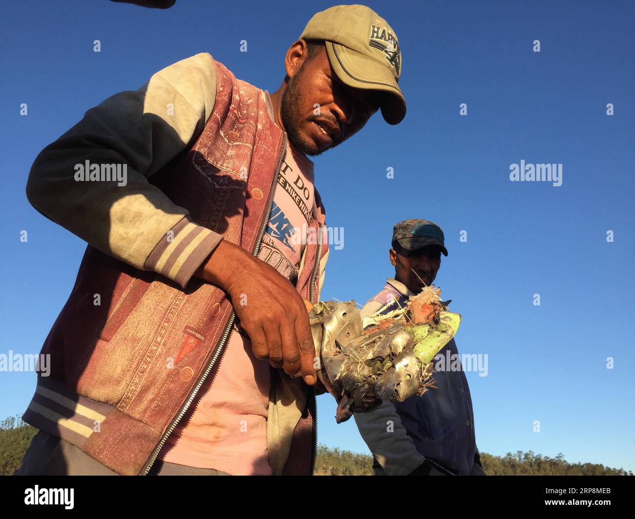(190311) -- ADDIS ABABA, March 11, 2019 (Xinhua) -- Photo taken with a mobile phone shows local people looking for wreckage of an Ethiopian Airlines aircraft at the crash site near Bishoftu town, about 45 km from the capital Addis Ababa, Ethiopia. The Nairobi-bound Boeing 737-8 MAX crashed on Sunday, just minutes from takeoff from Addis Ababa Bole International Airport, killing all 157 people aboard. Earlier on Monday, Ethiopian Airlines announced its decision to suspend commercial operations of all Boeing 737-Max 8 aircraft. (Xinhua/Michael Tewelde) ETHIOPIA-BISHOFTU-ETHIOPIAN AIRLINES-JET CR Stock Photo