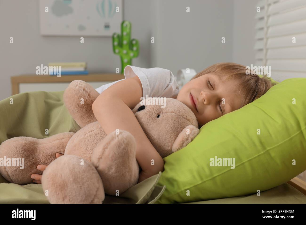 Little boy snoring while sleeping with teddy bear in bed at home Stock