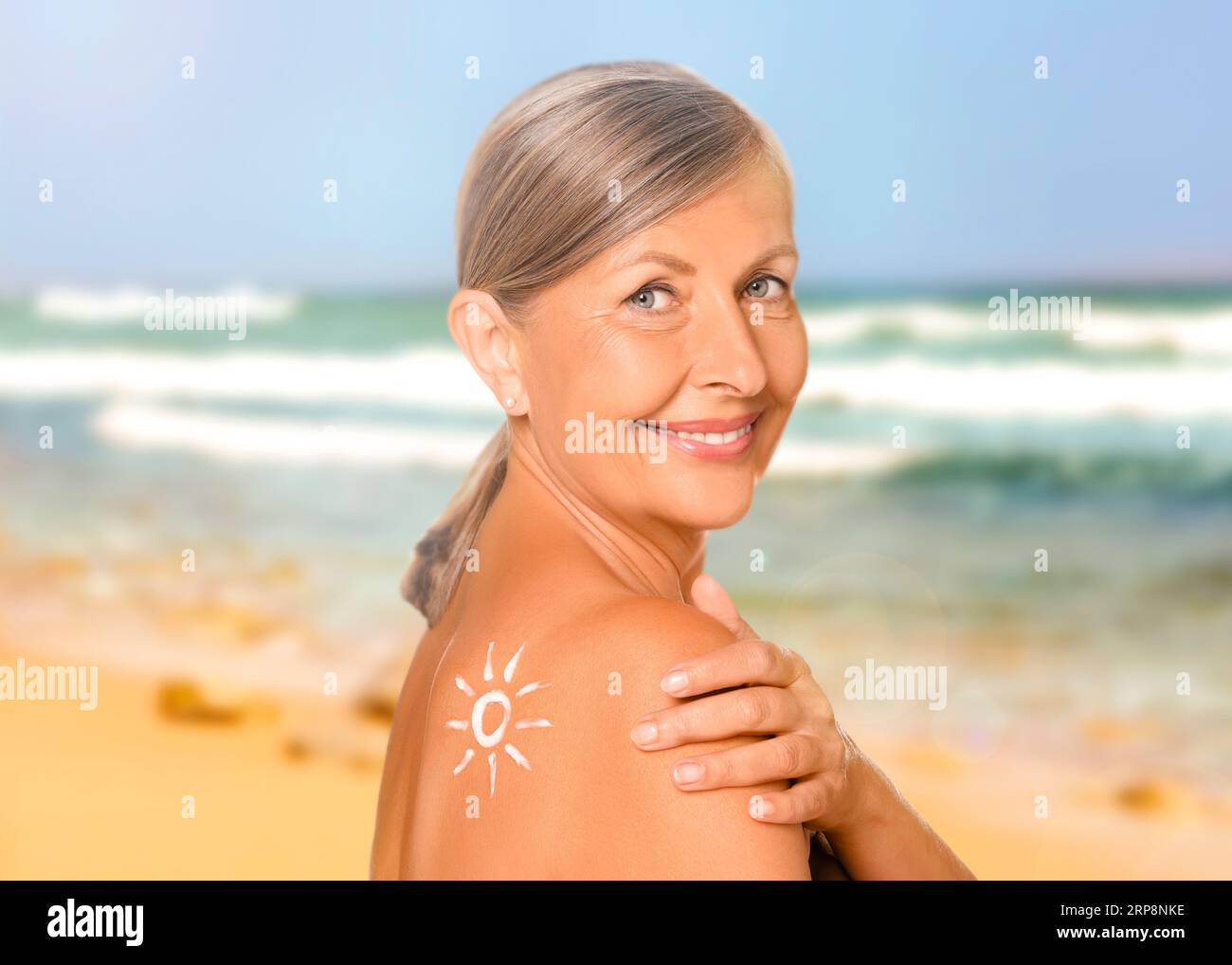Sun protection. Beautiful young woman with sunblock on her back near sea Stock Photo
