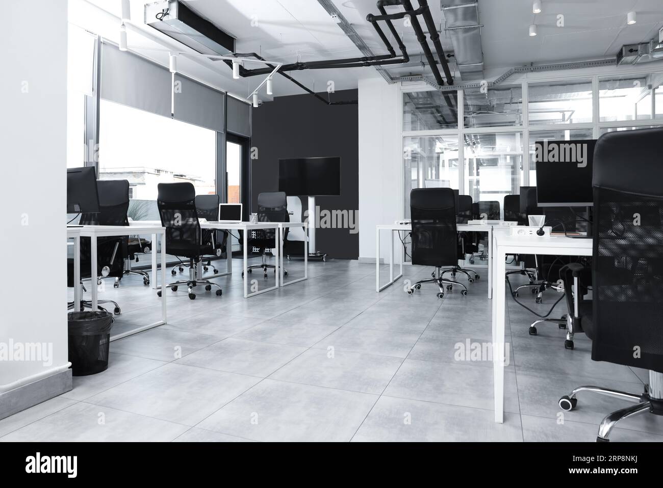 Stylish interior of open plan office. Workspace with tables and chairs ...