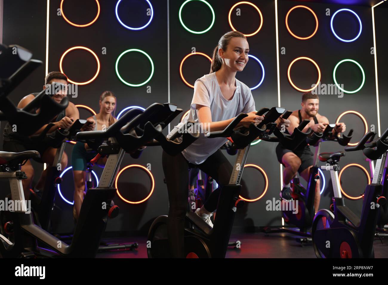 Group of people training on exercise bikes in fitness club Stock Photo ...