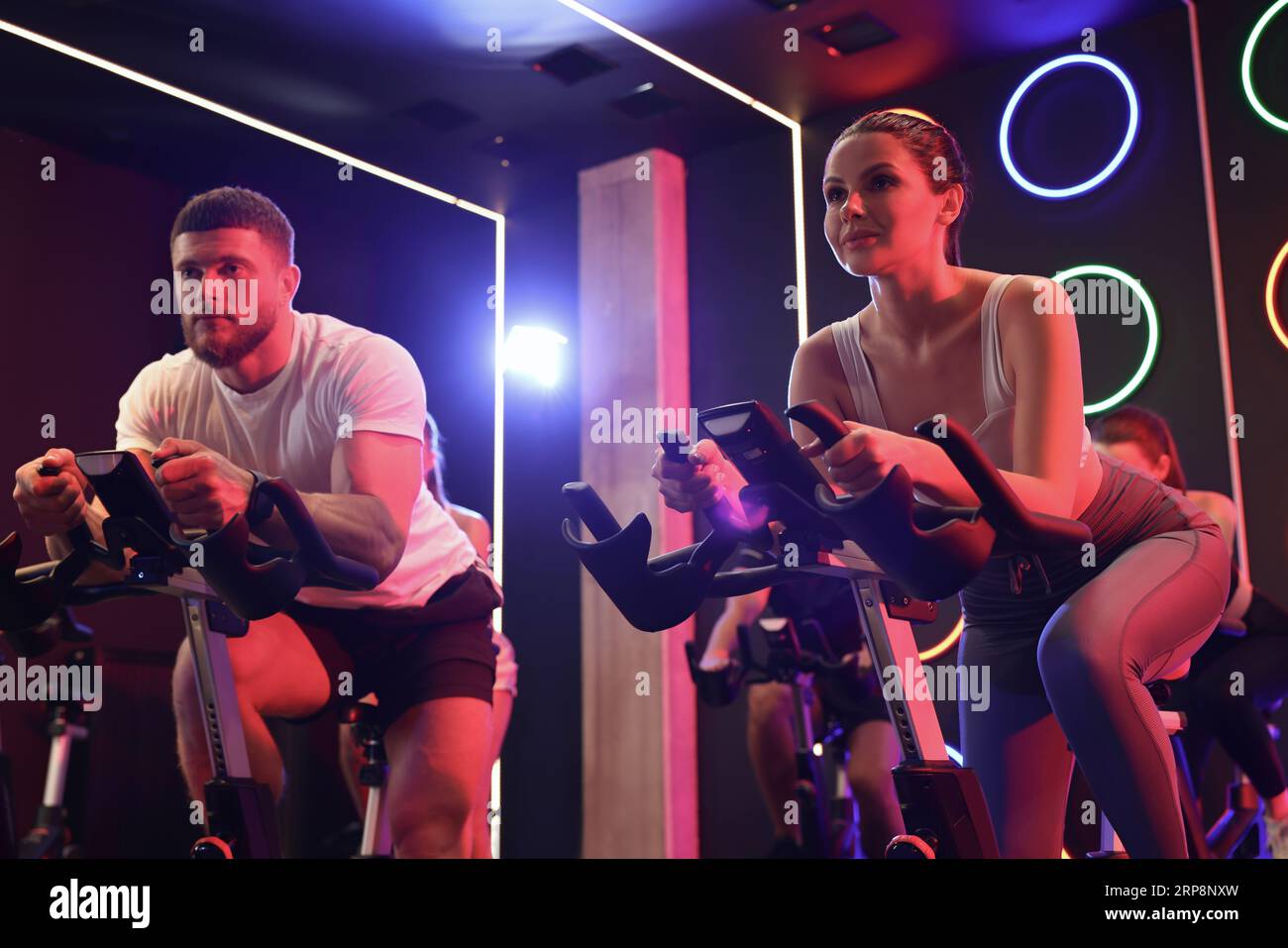 Group of people training on exercise bikes in fitness club Stock Photo ...