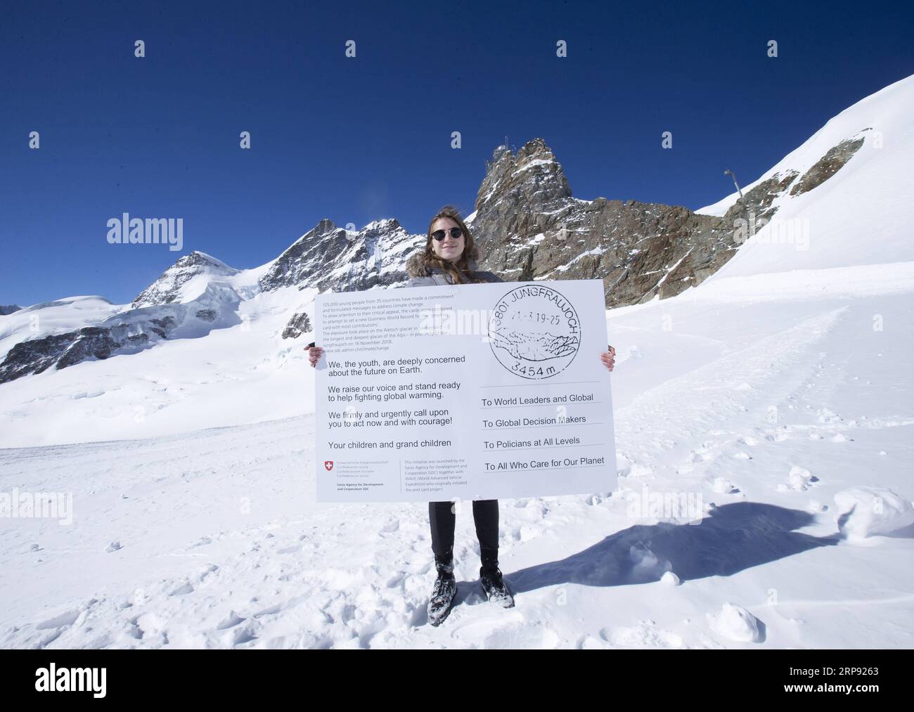 (190321) -- JUNGFRAUJOCH, March 21, 2019 (Xinhua) -- Swiss teenager Selma Schellenberg shows a copy of a postcard calling for action against climate change on the Aletsch glacier under Jungfraujoch in Switzerland, on March 20, 2019. Some 900 postcards from youths all over the world were stamped and sent on Wednesday from Europe s highest postbox on the Jungfraujoch peak, Switzerland, to global leaders, calling for action against climate change. (Xinhua/Xu Jinquan) SWITZERLAND-JUNGFRAUJOCH-CLIMATE CHANGE-POSTCARDS PUBLICATIONxNOTxINxCHN Stock Photo
